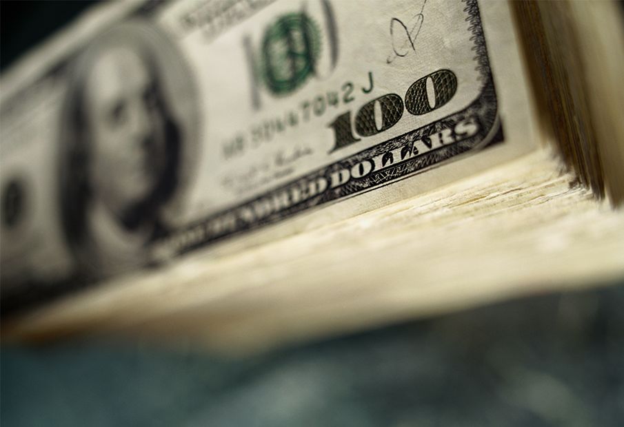 Stack of bills with a $100 bill on top