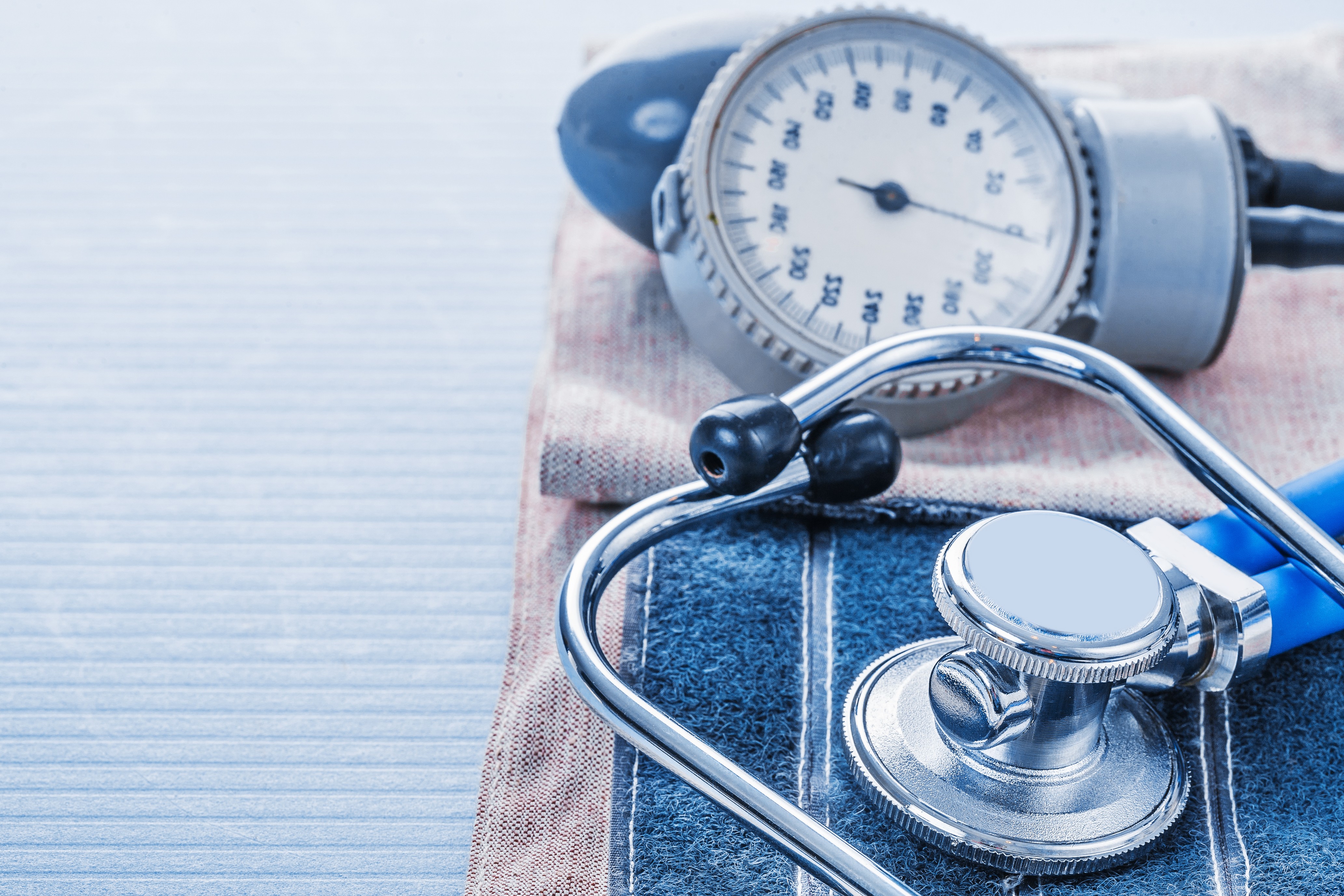 blood pressure monitor and stethoscope on blue background medica