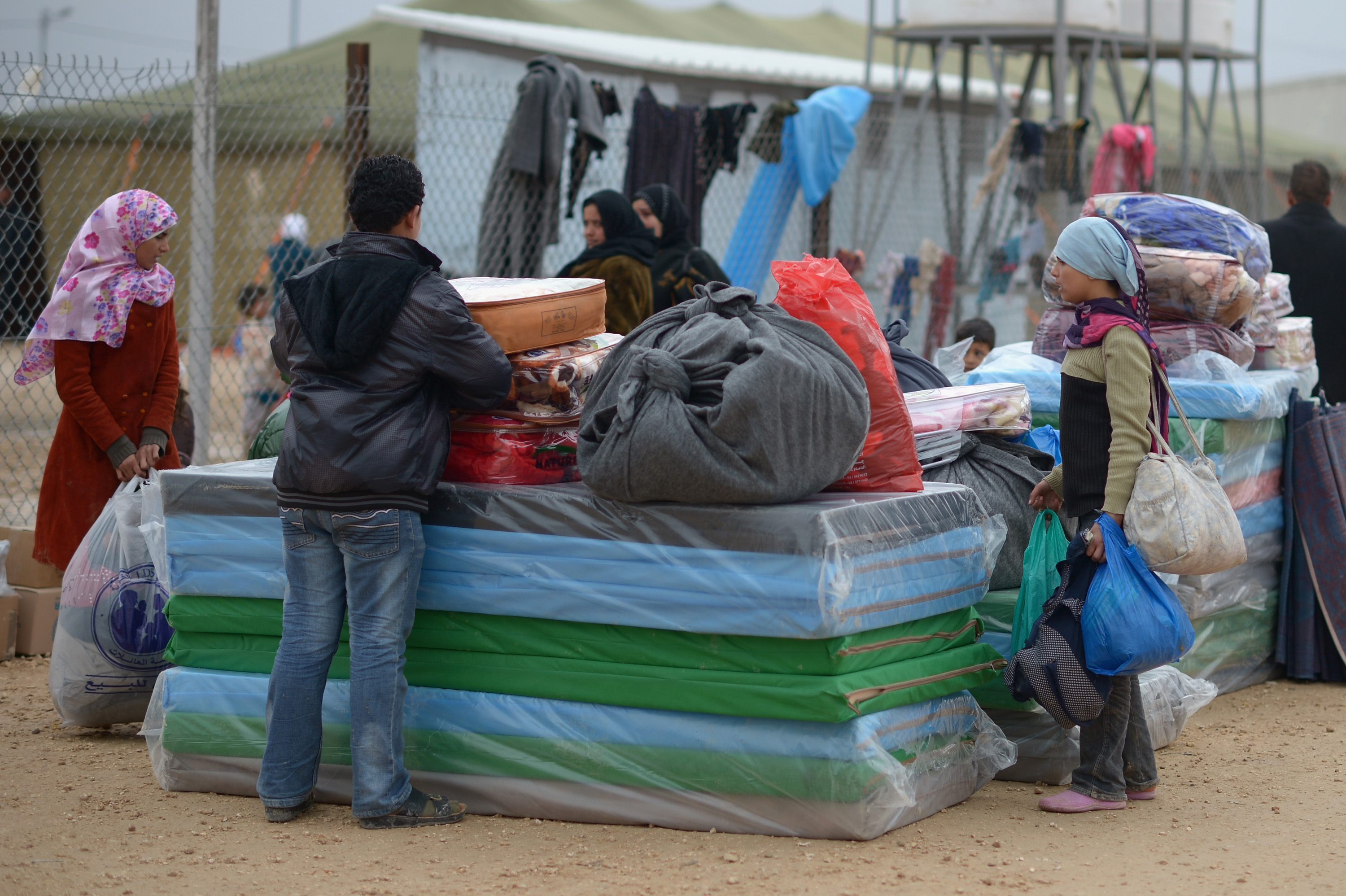 ZA'ATARI, JORDAN - FEBRUARY 01:  Refugees from Syria collect food and supplies from the UNHCR as they arrive at the Za'atari refugee camp on February 1, 2013 in Za'atari, Jordan. Record numbers of refugees are fleeing the violence and bombings in Syria to cross the borders to safety in northern Jordan and overwhelming the Za'atari camp. The Jordanian government are appealing for help with the influx of refugees as they struggle to cope with the sheer numbers arriving in the country.  (Photo by Jeff J Mitchell/Getty Images)