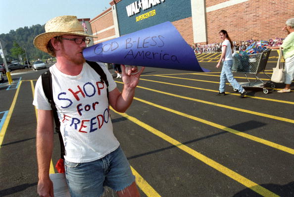 ATHENS, OH - AUGUST 14:  Ohio University graduate student Jeremy Ernst protests the grand opening of a Wal-Mart Supercenter August 14, 2002 in Athens, Ohio. Ernst accuses the store of stocking their shelves with products made in sweatshops. The 209,000-square-foot store will employ about 450 workers and is one of 17 Supercenters scheduled to open today around the U.S. along with four Wal-Mart Stores. Local residents are concerned that the opening of the store will threaten local businesses.  (Photo by Shaun Heasley/Getty Images)