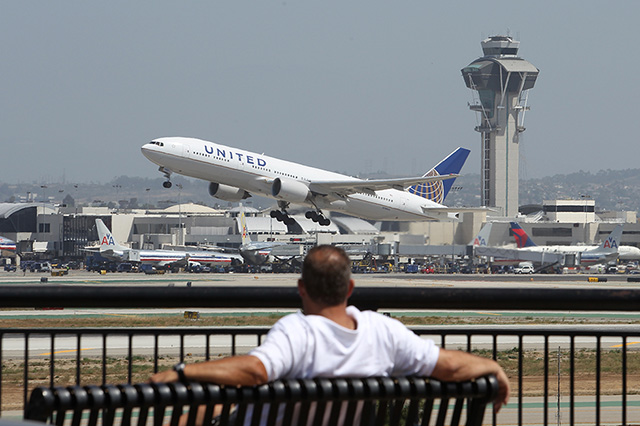 LOS ANGELES, CA - APRIL 22:  A United Airlines jet passes the air traffic control tower at Los Angles International Airport (LAX) during take-off on April 22, 2013 in Los Angeles, California. Delays have been reported throughout the nation because of the furloughing of air traffic controllers under sequestration. The average delay overnight in the Southern California Terminal Radius Approach Control (TRACON) was was three hours.  (Photo by David McNew/Getty Images)
