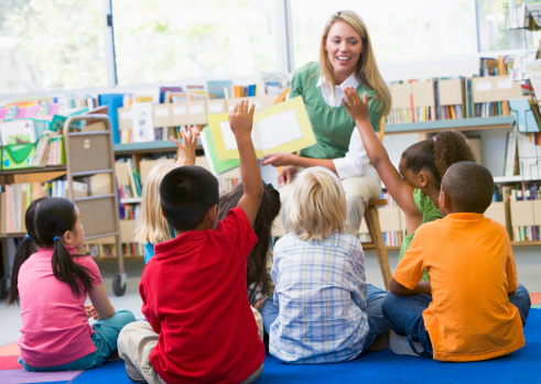 Kindergarten teacher reading to children