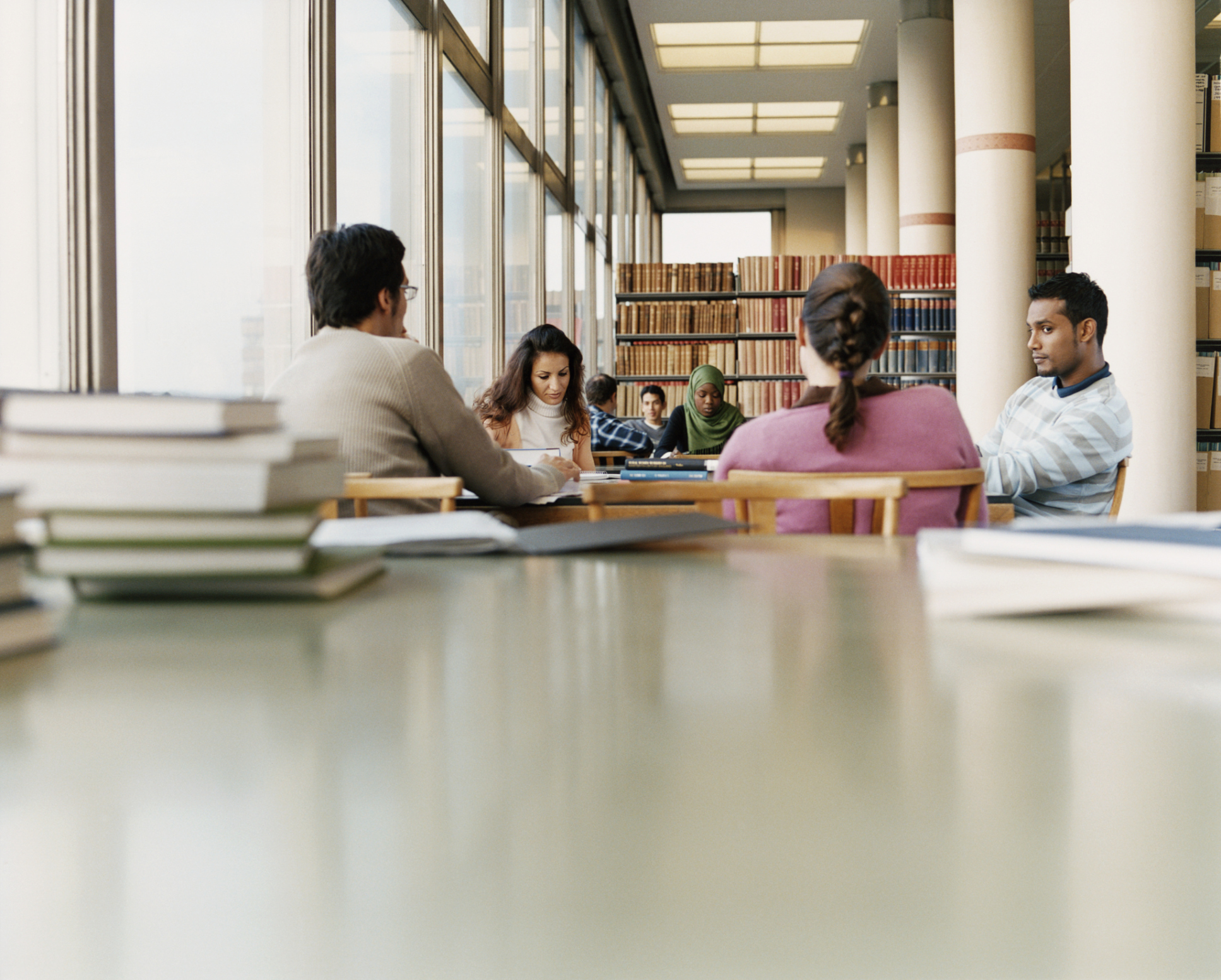 Surface Level Shot of Mature Students Sitting at a Table in a University Library