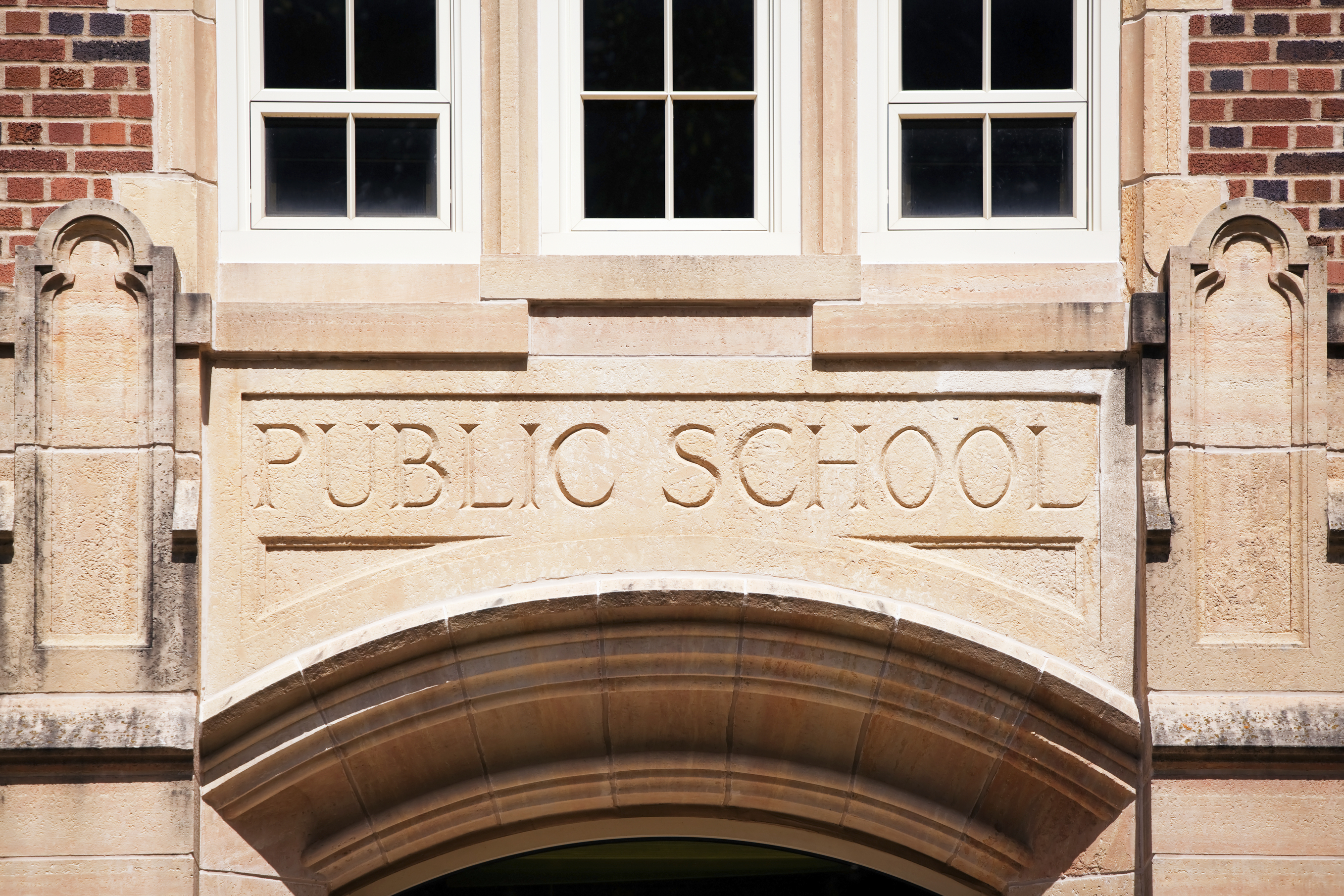 A Public School sign carved in granite about the entrance to an old high school.