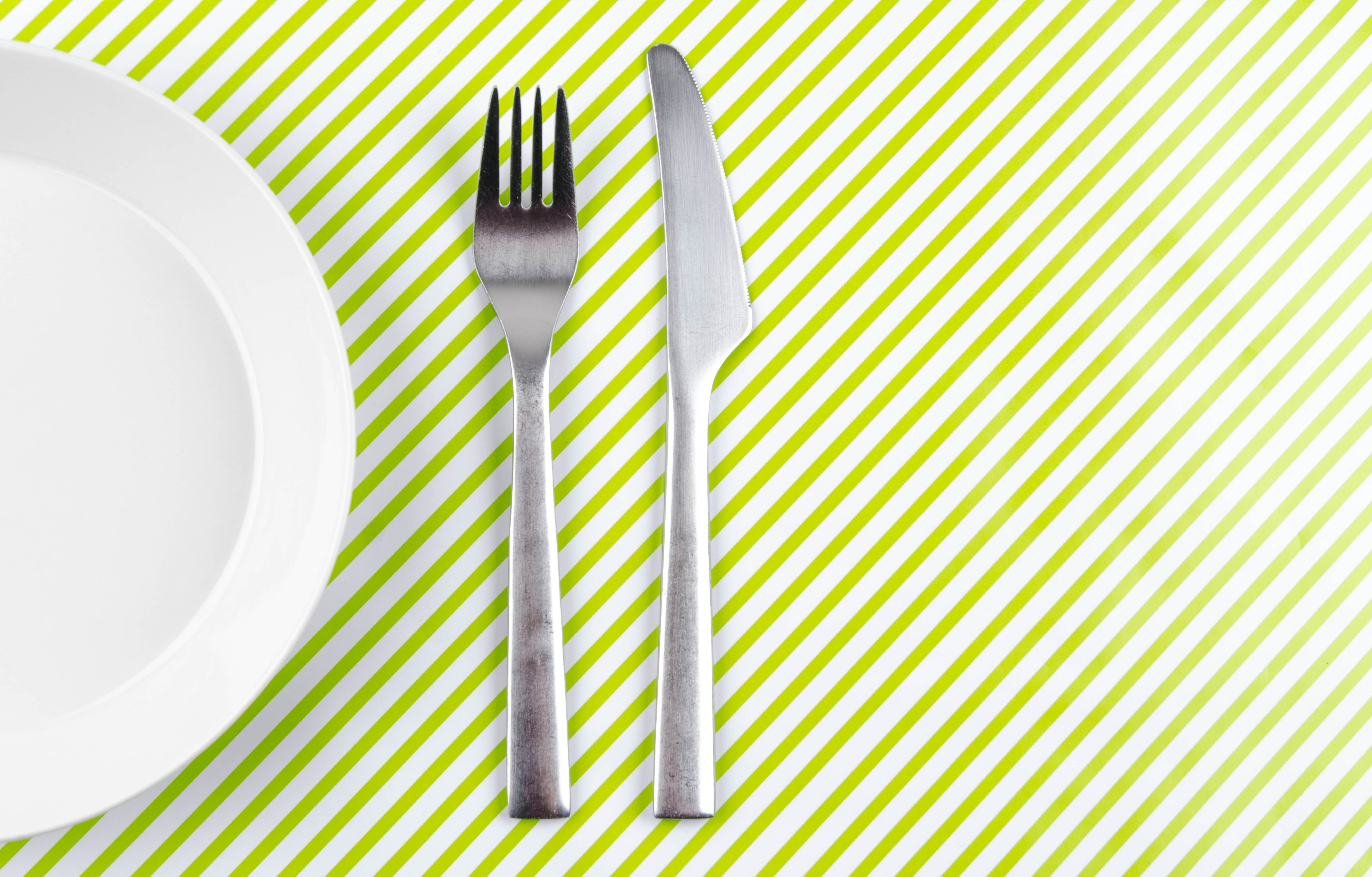 Old crockery on vintage 60s or 70s tablecloth.  View from above with copy space. High quality indoor shot. Copy space for your text or logo. Dish has scratches and looks used.