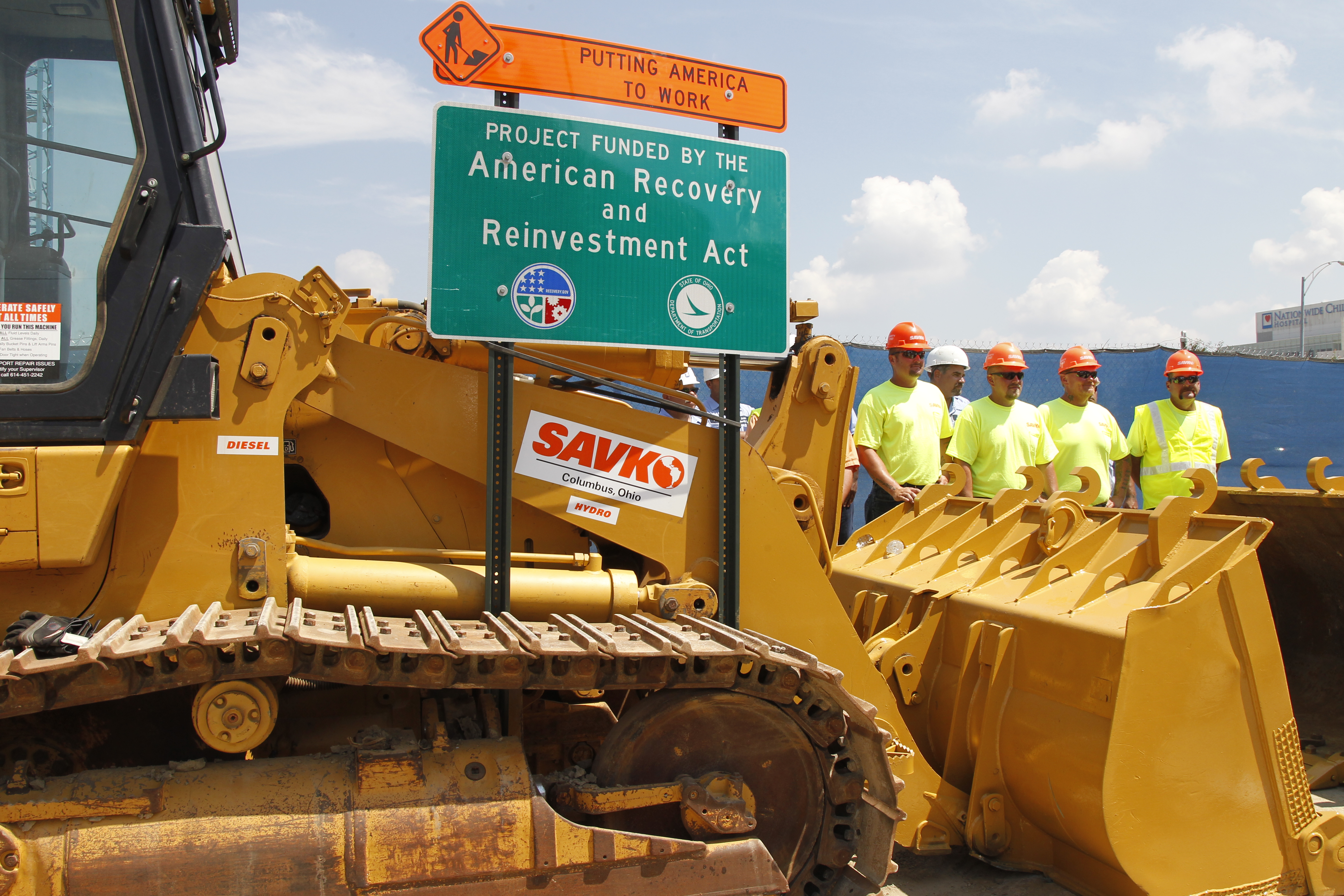 Construction workers look on before the arrival President Barack Obama at a highway road project funded by the American Recovery and Reinvestment Act in Columbus, Ohio, Friday, June 18, 2010. (AP Photo/Charles Dharapak)