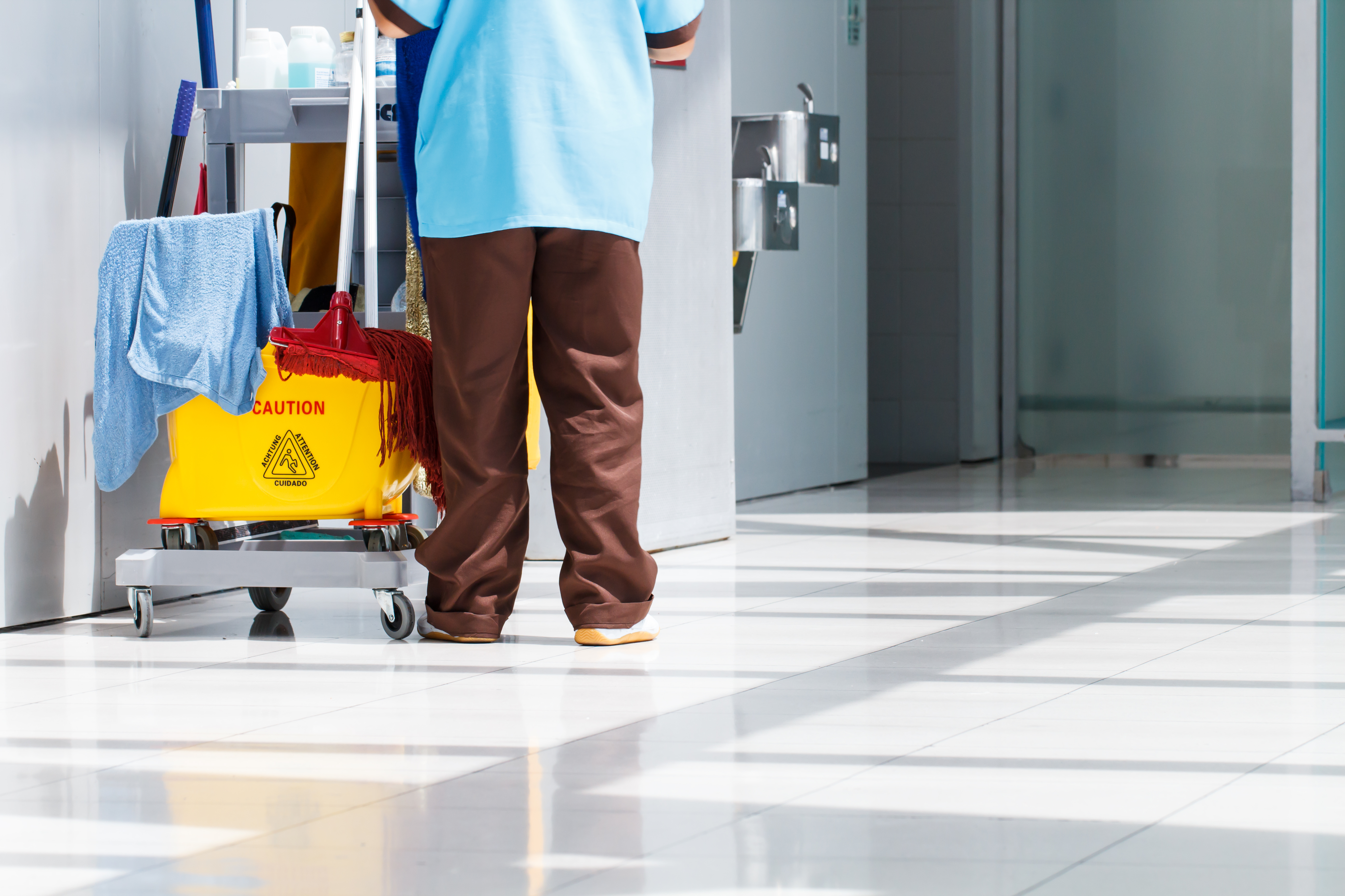 Mop bucket on cleaning in process and worker