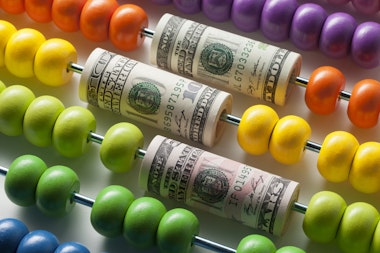 Abacus with rolls of dollar banknotes.