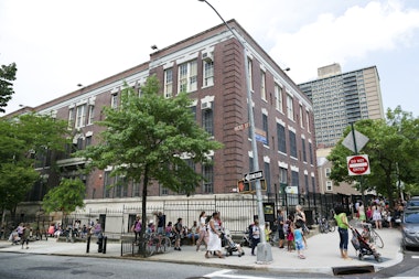 New York City, USA - June 17, 2013: Large school building in Brooklyn at the corner of Hicks Street and Middagh Street. Parents and nanny's pick up the kids after school.