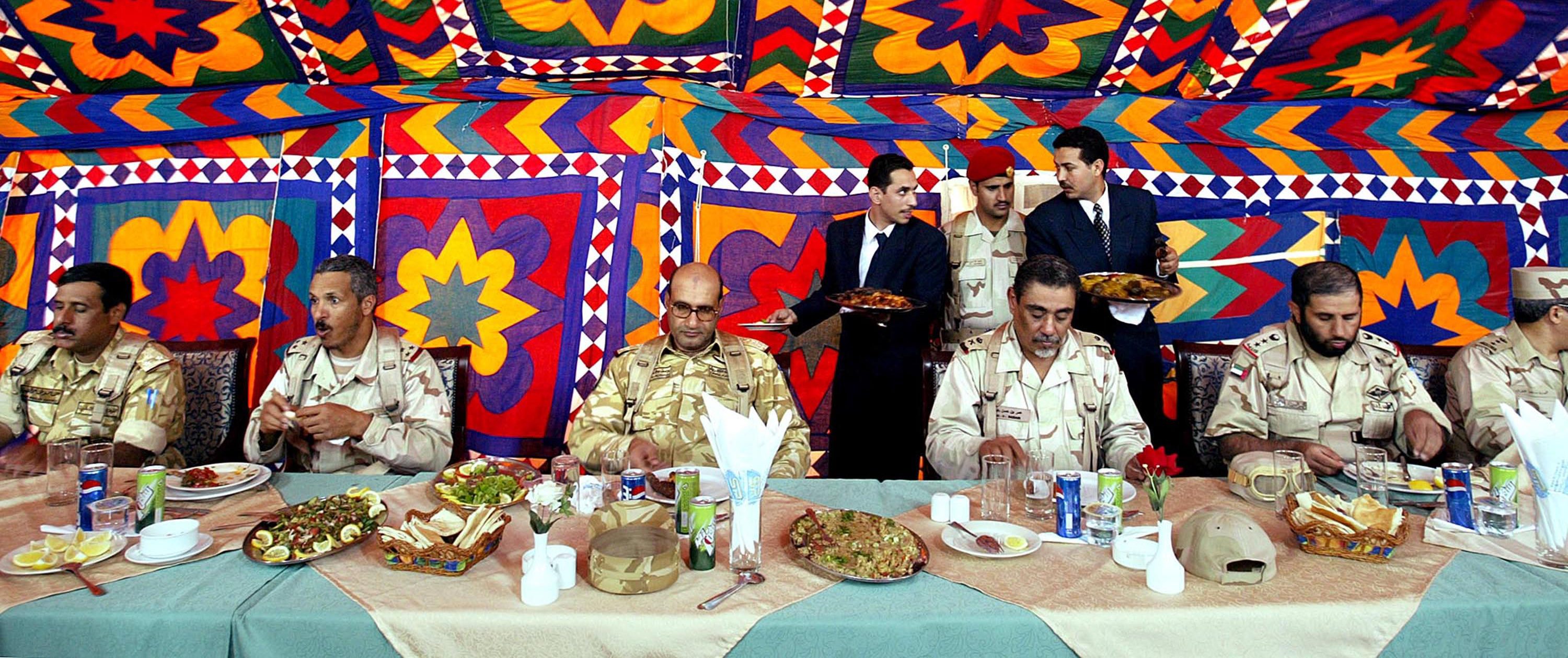 SALMI, KUWAIT - MARCH 25:  Members of the Peninsula Shield force eat lunch at a security station 25 miles from the Kuwait-Iraq border March 25, 2003 in Salmi, Kuwait. The 10,000 man unit combines forces from member states of the Gulf Cooperation Council (GCC)- Saudi Arabia, United Arab Emirates, Oman, Bahrain, Qatar and Kuwait in an effort to help defend the joint border of Saudi Arabia, Kuwait and Iraq.  (Photo by Mario Tama/Getty Images)