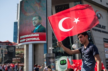 ANKARA, TURKEY - JULY 16: A man waves a Turkish flag from the roof of a car during a march around Kizilay Square in reaction to the attempted military coup on July 16, 2016 in Ankara, Turkey. Police regained control overnight after an attempted military coup against President Recep Tayyip Erdogan. The coup attempt claimed over 250 lives. President Erdogan urged his supporters to take to the streets in support to prevent any further flare ups.  (Photo by Chris McGrath/Getty Images)