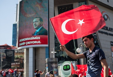 ANKARA, TURKEY - JULY 16: A man waves a Turkish flag from the roof of a car during a march around Kizilay Square in reaction to the attempted military coup on July 16, 2016 in Ankara, Turkey. Police regained control overnight after an attempted military coup against President Recep Tayyip Erdogan. The coup attempt claimed over 250 lives. President Erdogan urged his supporters to take to the streets in support to prevent any further flare ups.  (Photo by Chris McGrath/Getty Images)