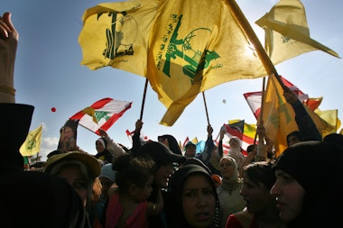 BEIRUT, LEBANON- SEPTEMBER 22: Hezbollah supporters wave flags during a ''Victory over Israel'' rally in Beirut's suburbs on September 22, 2006 in Beirut, Lebanon. Hezbollah leader Sayyed Hassan Nasrallah reportedly said that Hezbollah would not disarm until a Lebanese government capable of protecting the country was in place during the rally.  (Photo by Salah Malkawi/Getty Images)