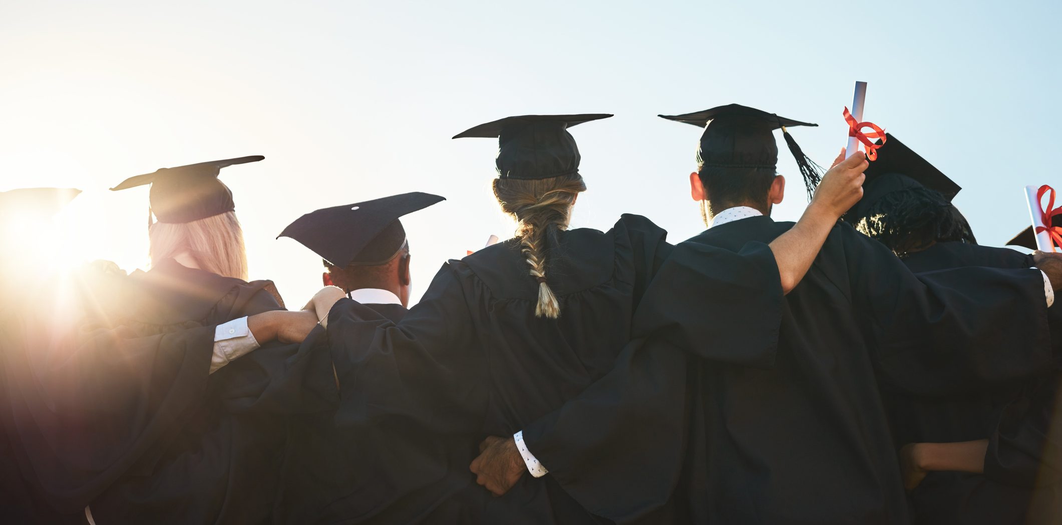Rearview shot of a group of university students standing outside on graduation day