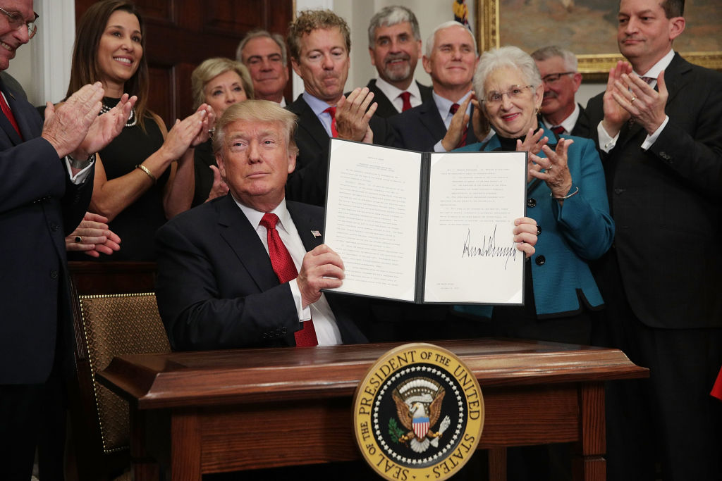 WASHINGTON, DC - OCTOBER 12:  U.S. President Donald Trump shows an executive order after he signed it as Sen. Rand Paul (R-KY), Vice President Mike Pence, Rep. Virginia Foxx (R-NC) and Secretary of Labor Alexander Acosta look on during an event in the Roosevelt Room of the White House October 12, 2017 in Washington, DC. President Trump signed the executive order to loosen restrictions on Affordable Care Act 