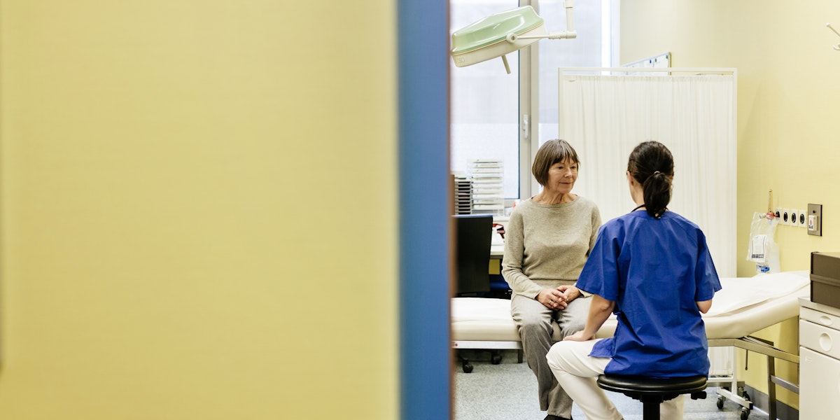 Mature female doctor talking to a female senior patient in doctors office