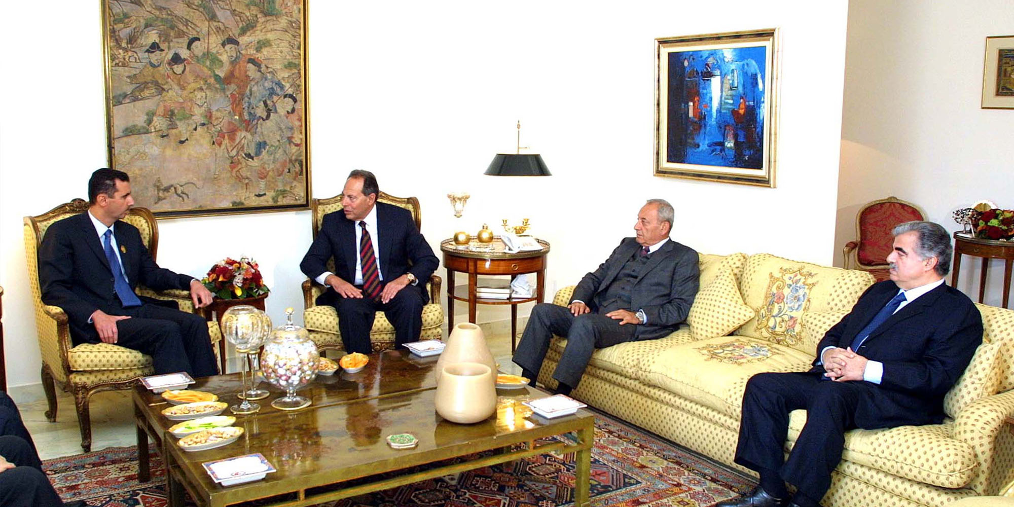 a group of men sitting around a living room together