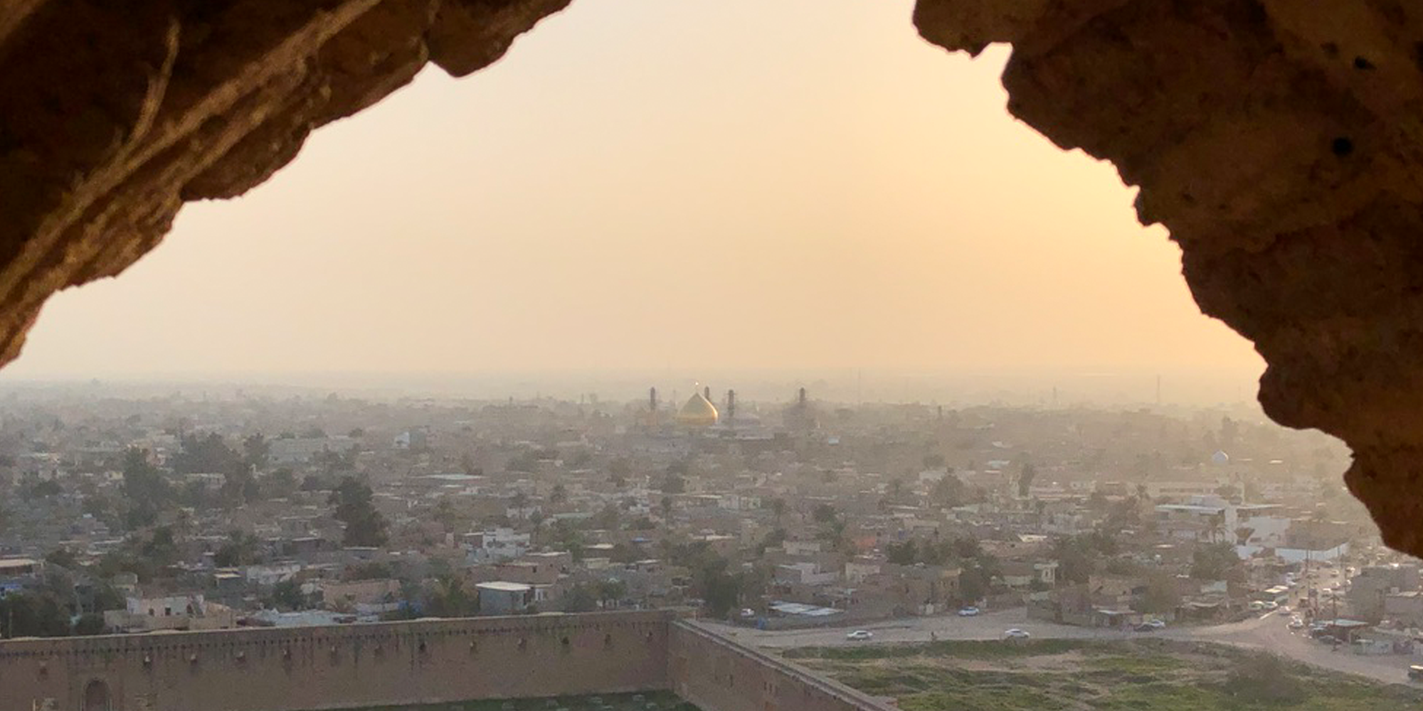 A horizon of a city shot through a cave