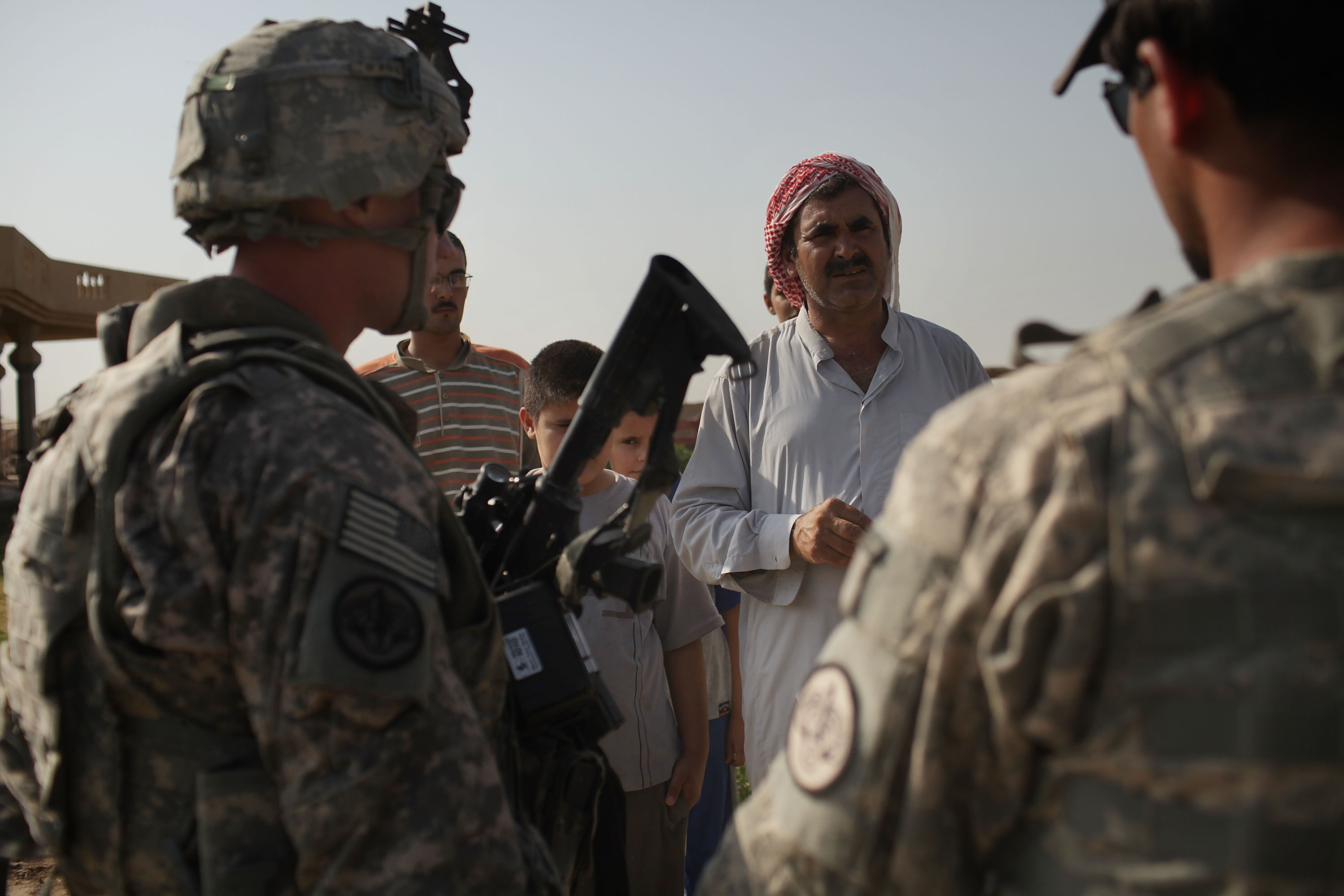 ISKANDARIYA, IRAQ - JULY 13: Soldiers and an Iraqi translator with the 3rd Armored Cavalry Regiment speak with a local Iraqi while on  a patrol on July 13, 2011 in Iskandariya, Iraq. As the deadline for the departure of the remaining American forces in Iraq approaches, Iraqi politicians have agreed to meet in two weeks time in order to give a final decision about extending the U.S. troops' presence beyond the end of the 2011 deadline. Violence against foreign troops has recently picked-up with June being the worst month in combat-related deaths for the military in Iraq in more than two years. Currently about 46,000 U.S. soldiers remain in Iraq.  (Photo by Spencer Platt/Getty Images)