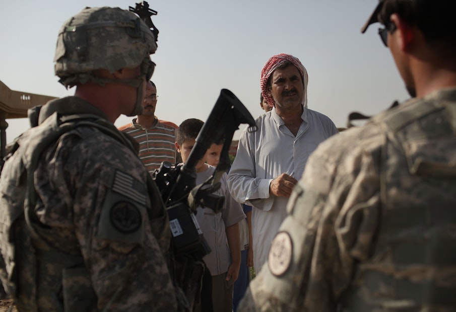 ISKANDARIYA, IRAQ - JULY 13: Soldiers and an Iraqi translator with the 3rd Armored Cavalry Regiment speak with a local Iraqi while on a patrol on July 13, 2011 in Iskandariya, Iraq. As the deadline for the departure of the remaining American forces in Iraq approaches, Iraqi politicians have agreed to meet in two weeks time in order to give a final decision about extending the U.S. troops' presence beyond the end of the 2011 deadline. Violence against foreign troops has recently picked-up with June being the worst month in combat-related deaths for the military in Iraq in more than two years. Currently about 46,000 U.S. soldiers remain in Iraq. (Photo by Spencer Platt/Getty Images)