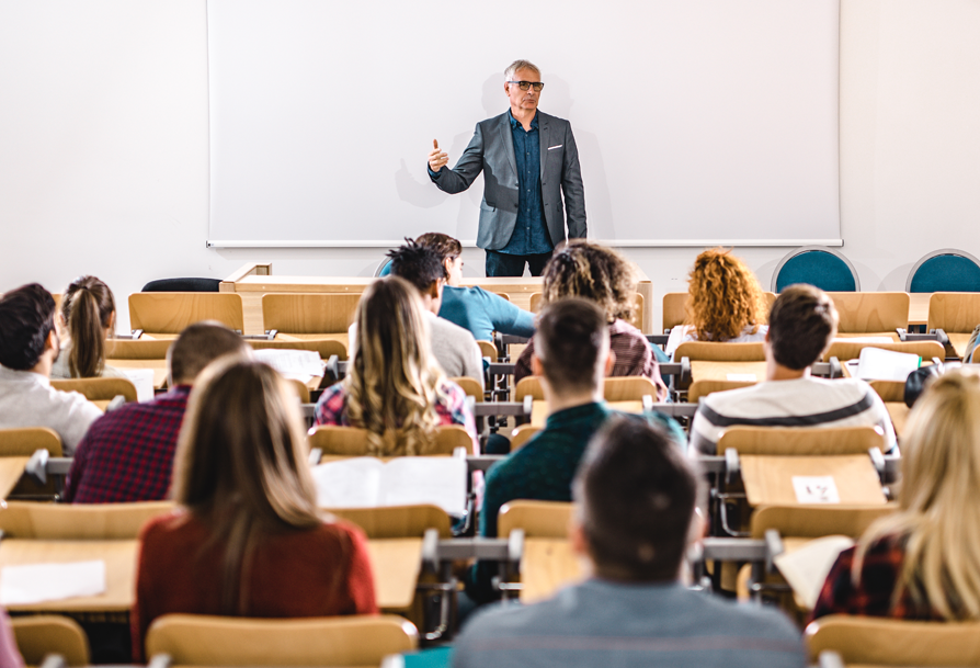 a man standing in front of a class room full of people