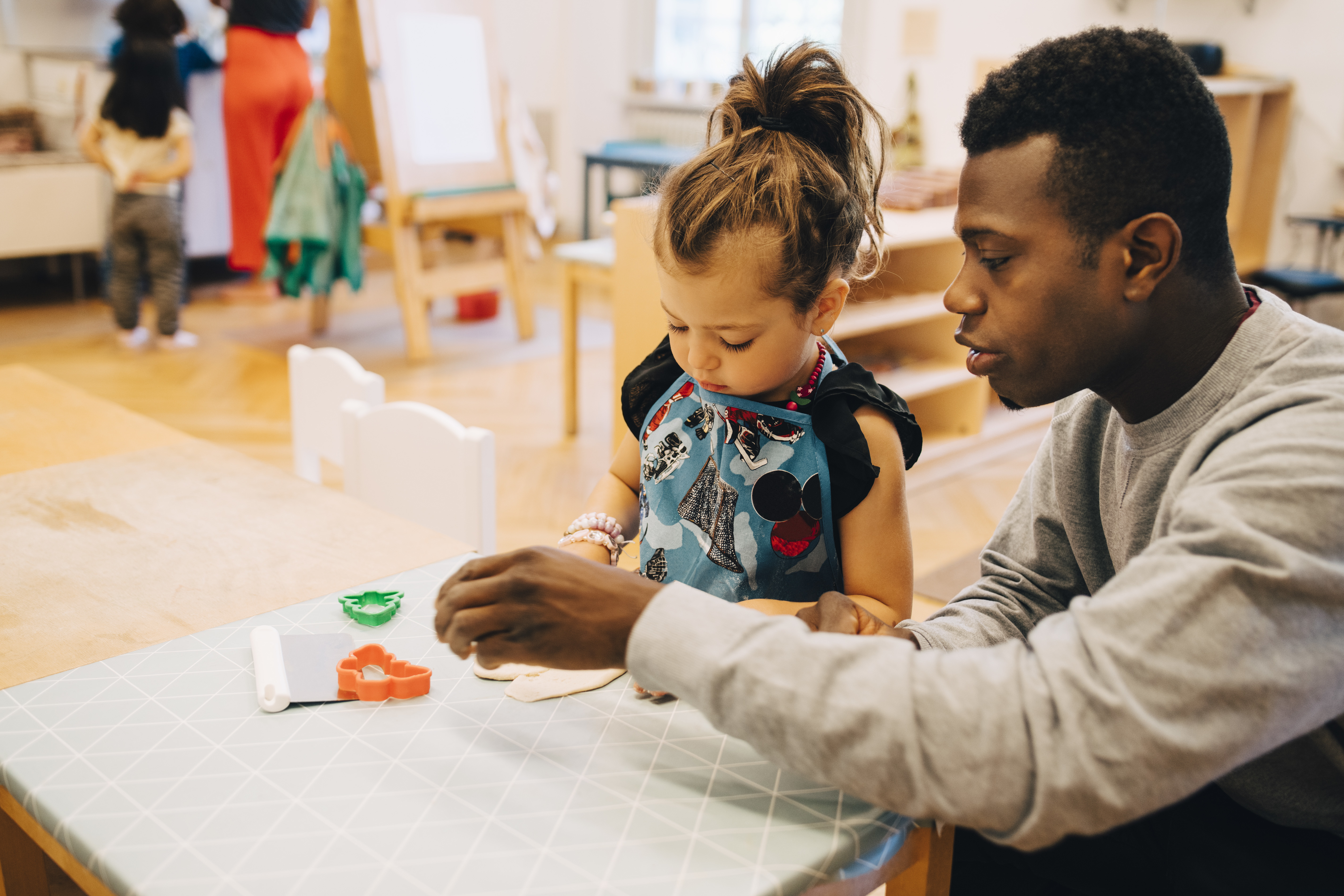a man and a little girl sitting at a table