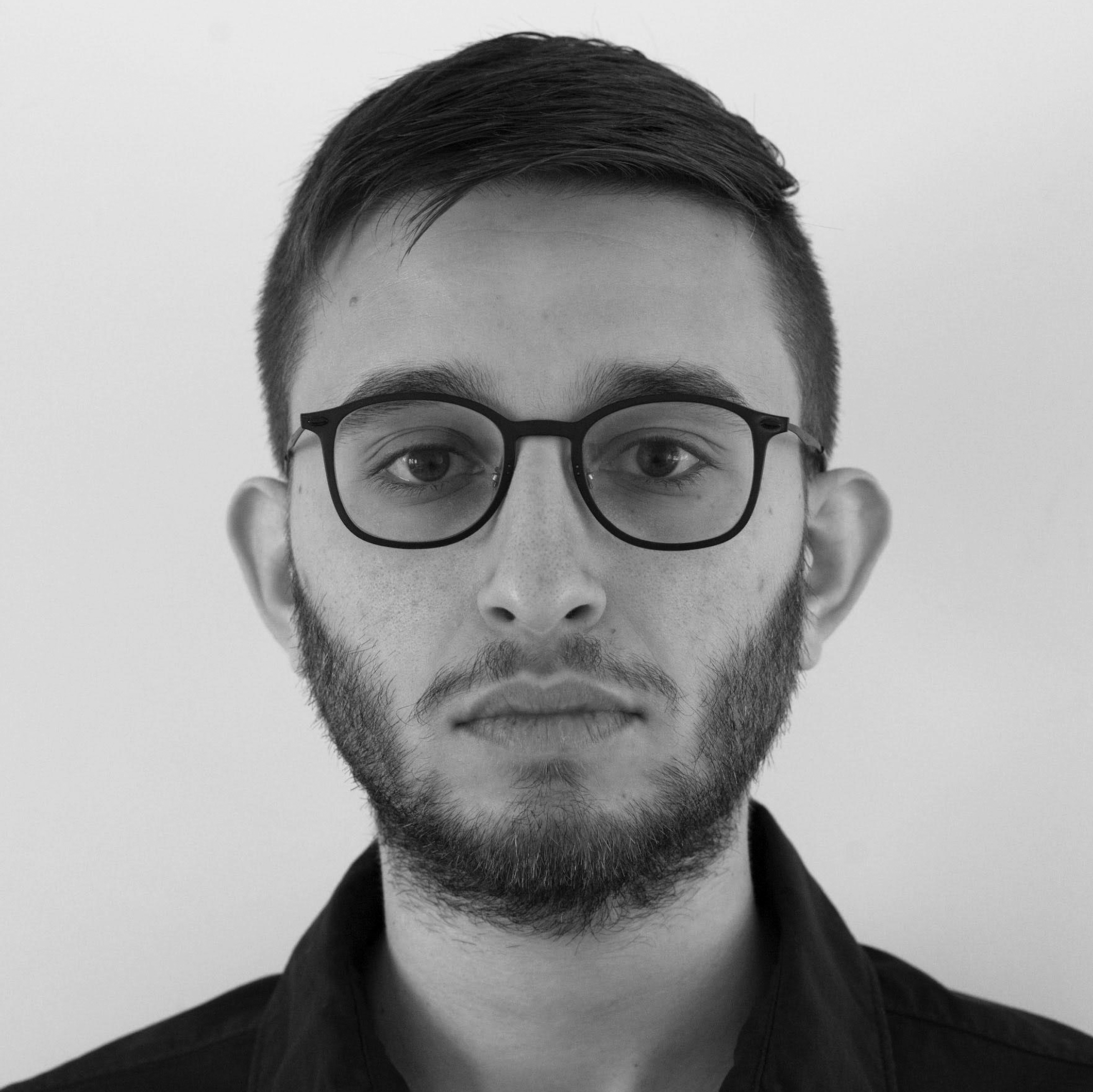 a black and white photo of a man wearing glasses