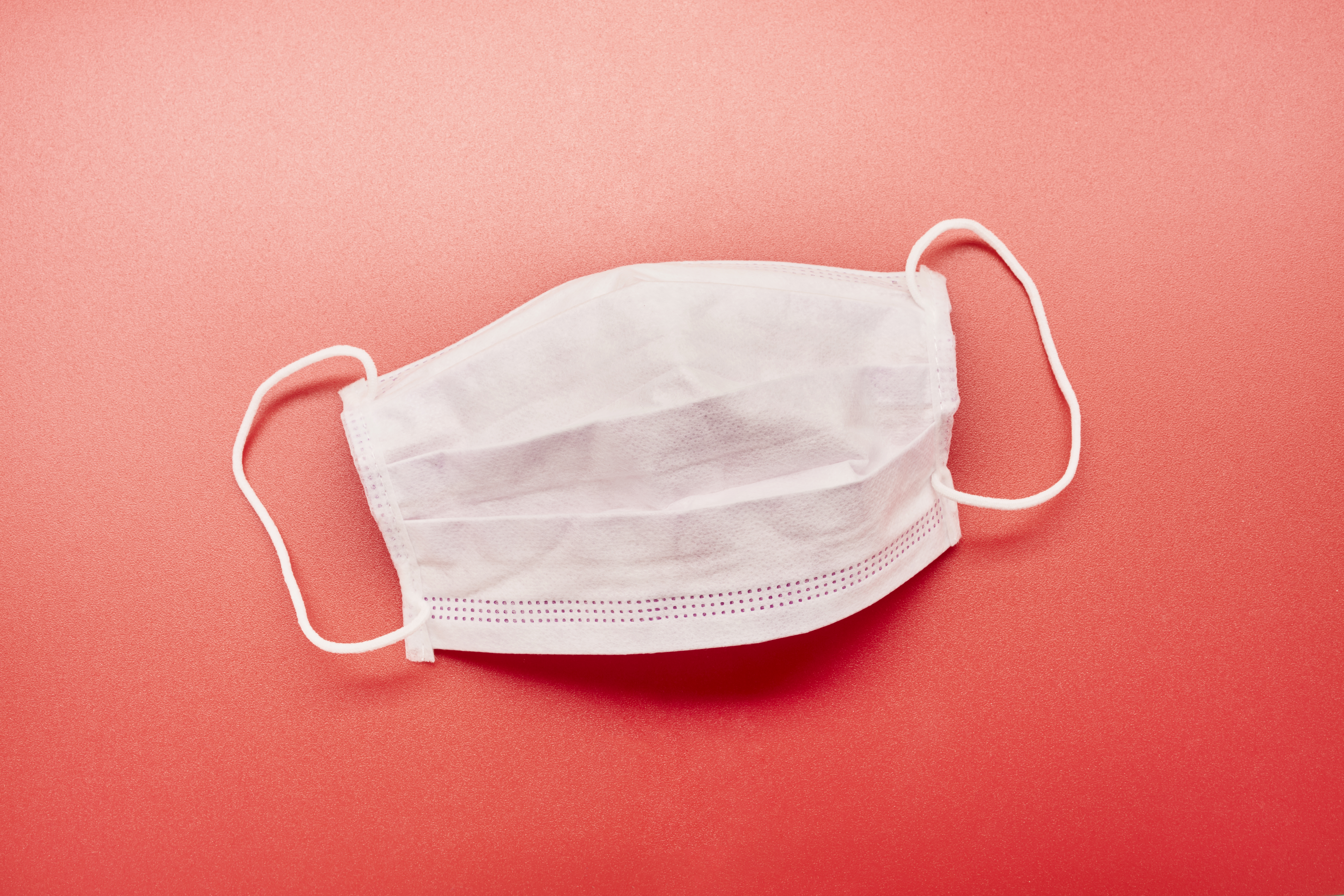 Still life of a face mask on red background