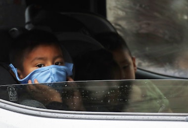 VAN NUYS, CALIFORNIA - APRIL 09: A boy wears a face mask as food is delivered to his truck at a Food Bank distribution for those in need as the coronavirus pandemic continues on April 9, 2020 in Van Nuys, California. Organizers said they had distributed food for 1,500 families amid the spread of COVID-19. (Photo by Mario Tama/Getty Images)