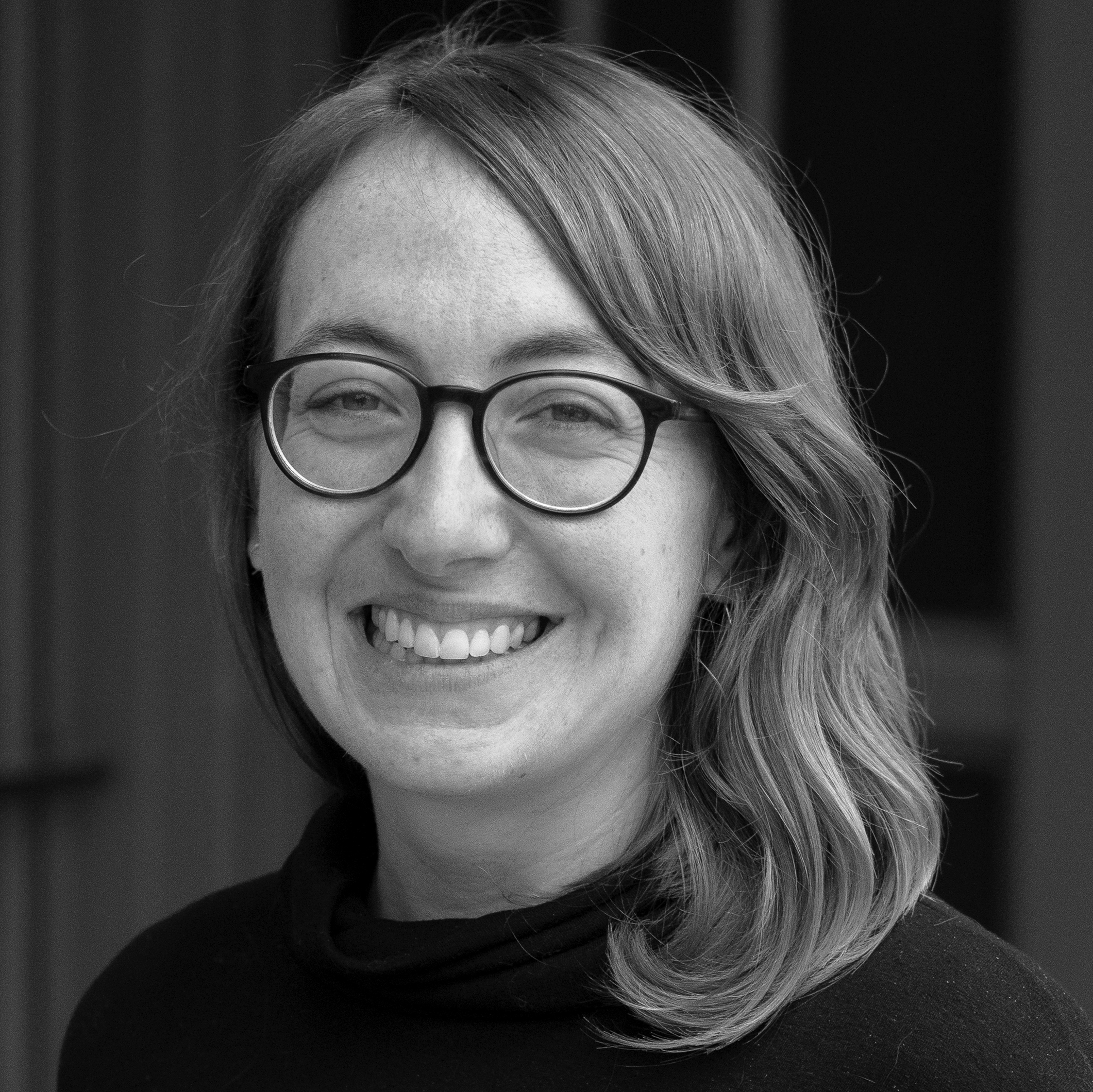 a black and white photo of a woman wearing glasses