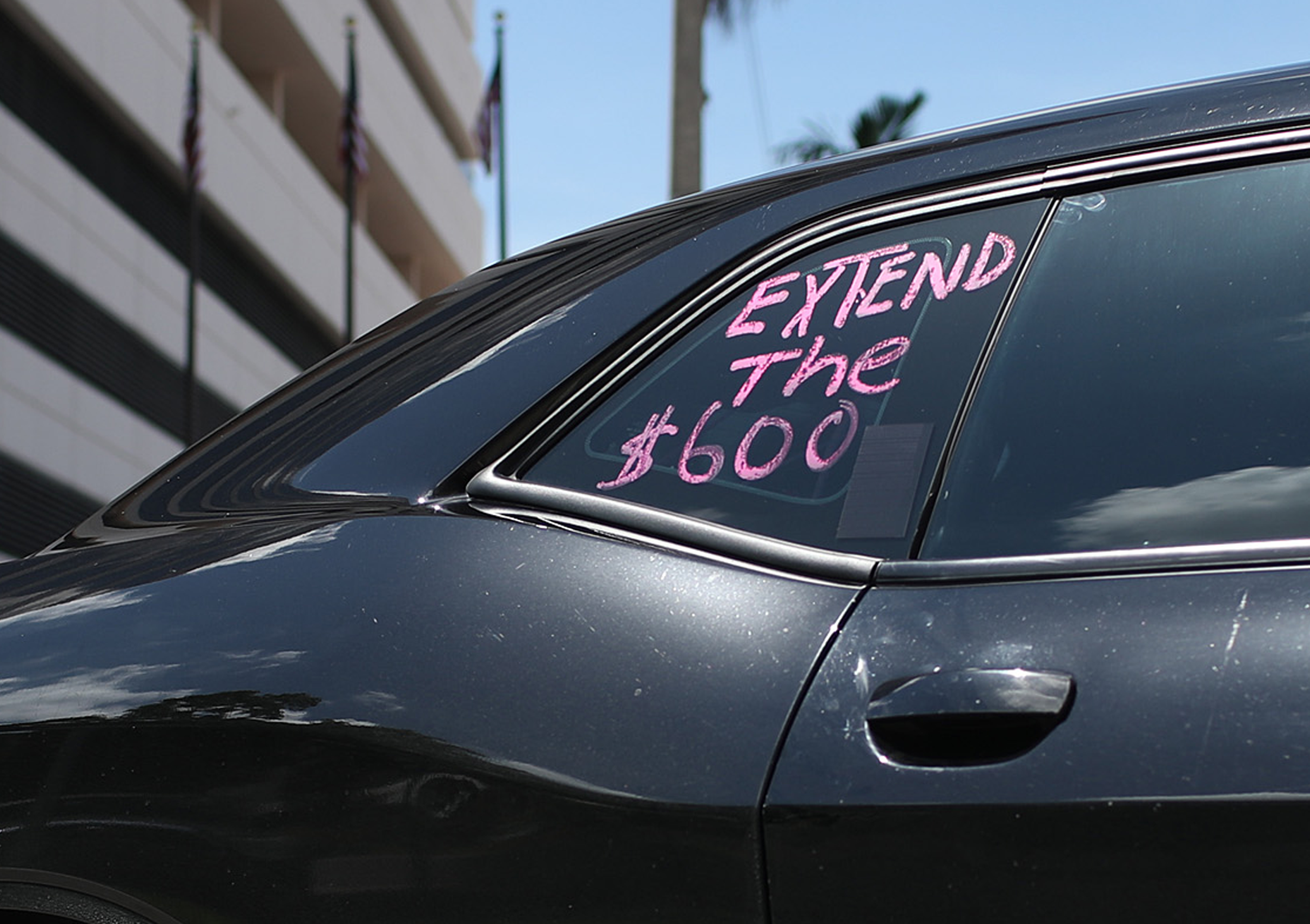 a black car with a pink sticker on it