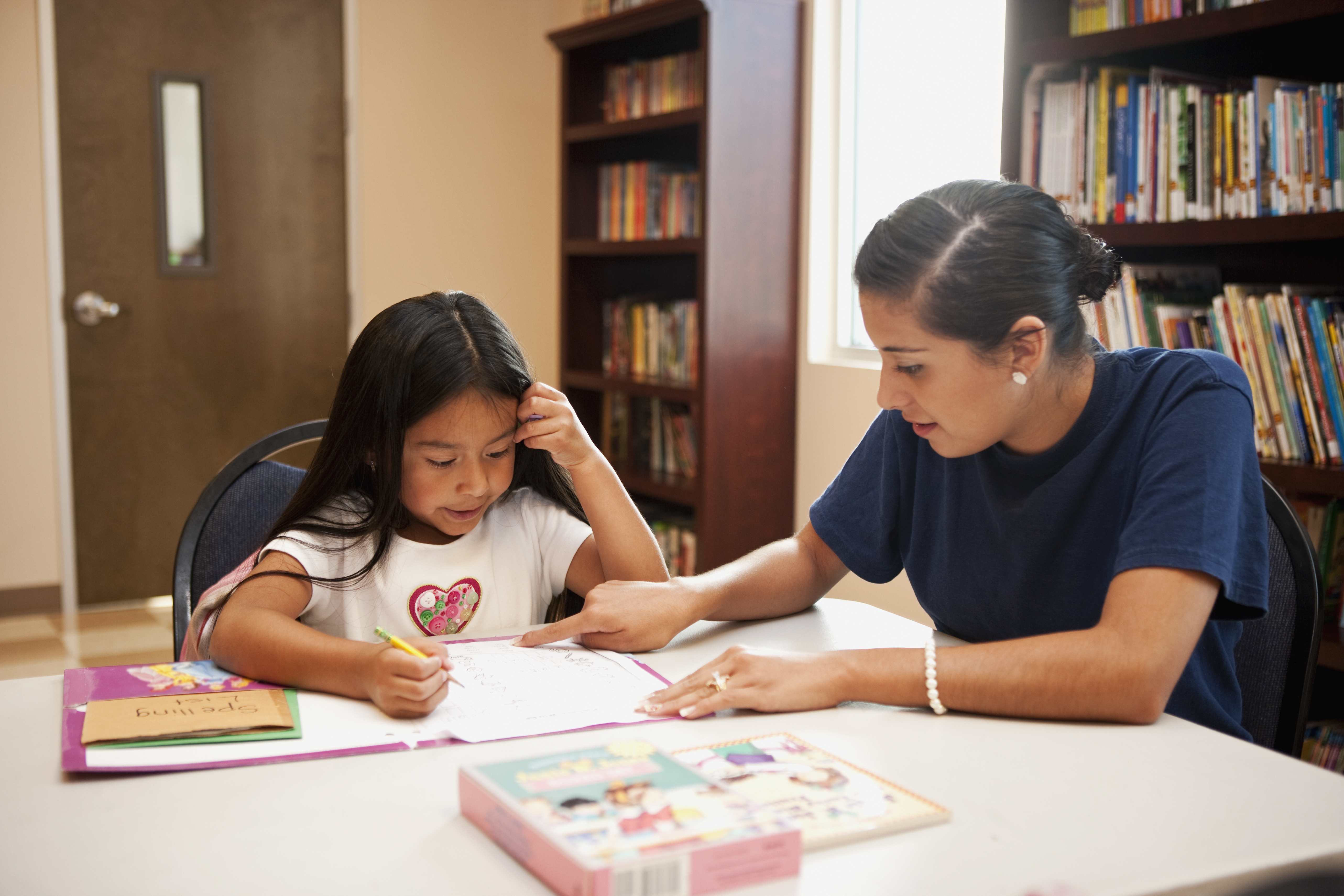 a woman sitting at a table with a little girl