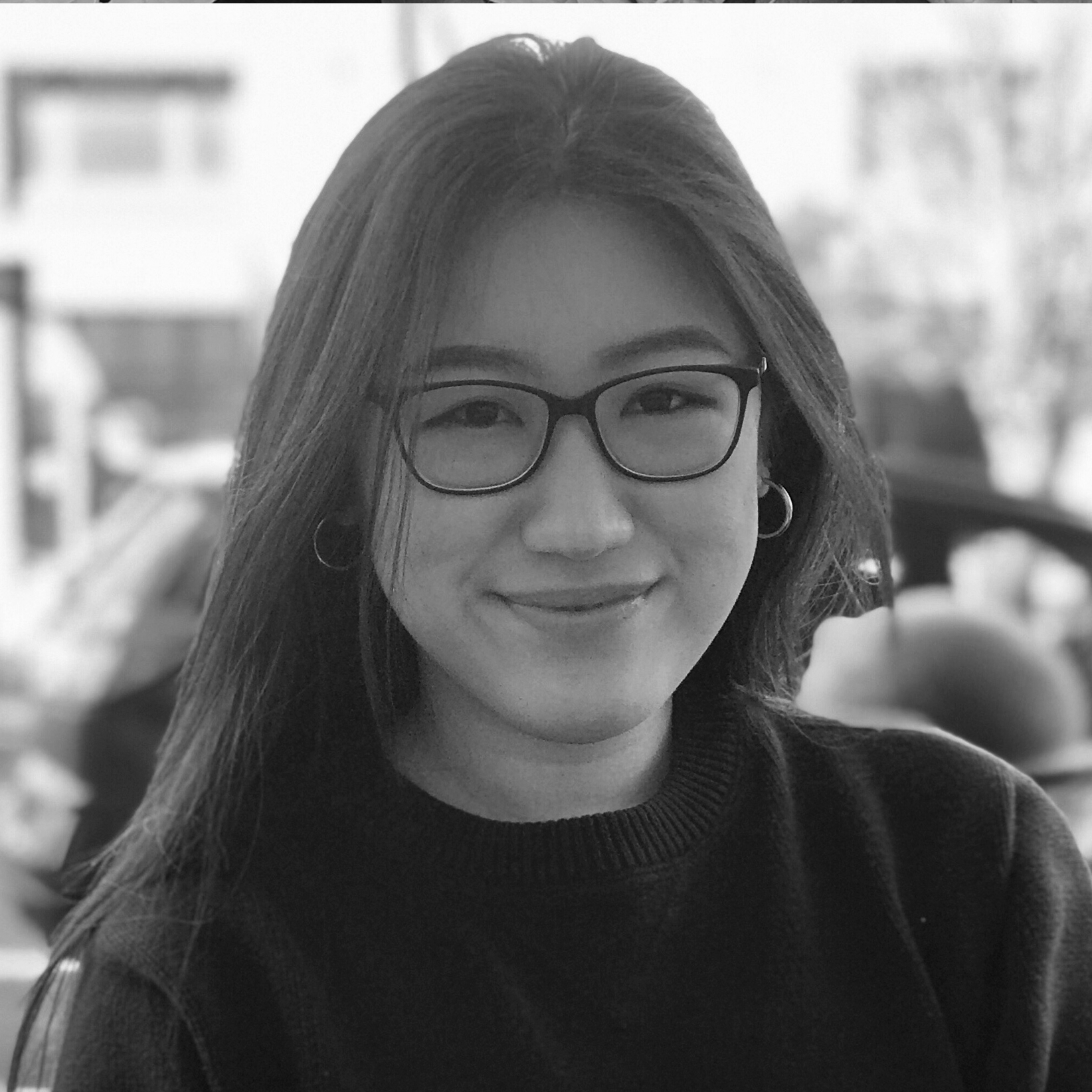 a black and white photo of a woman wearing glasses