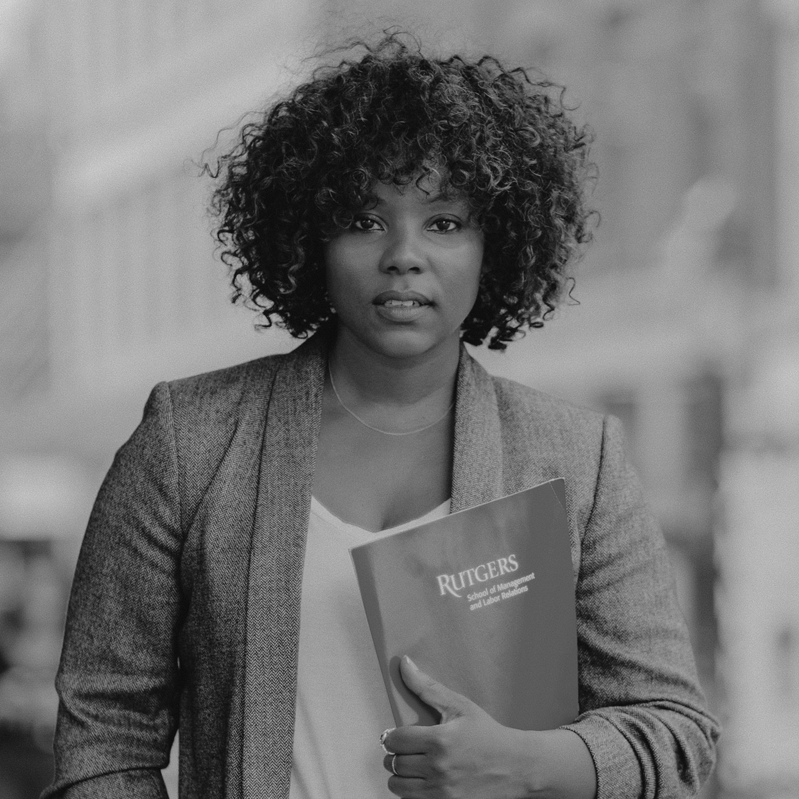 A lady holding a folder that says Rutgers