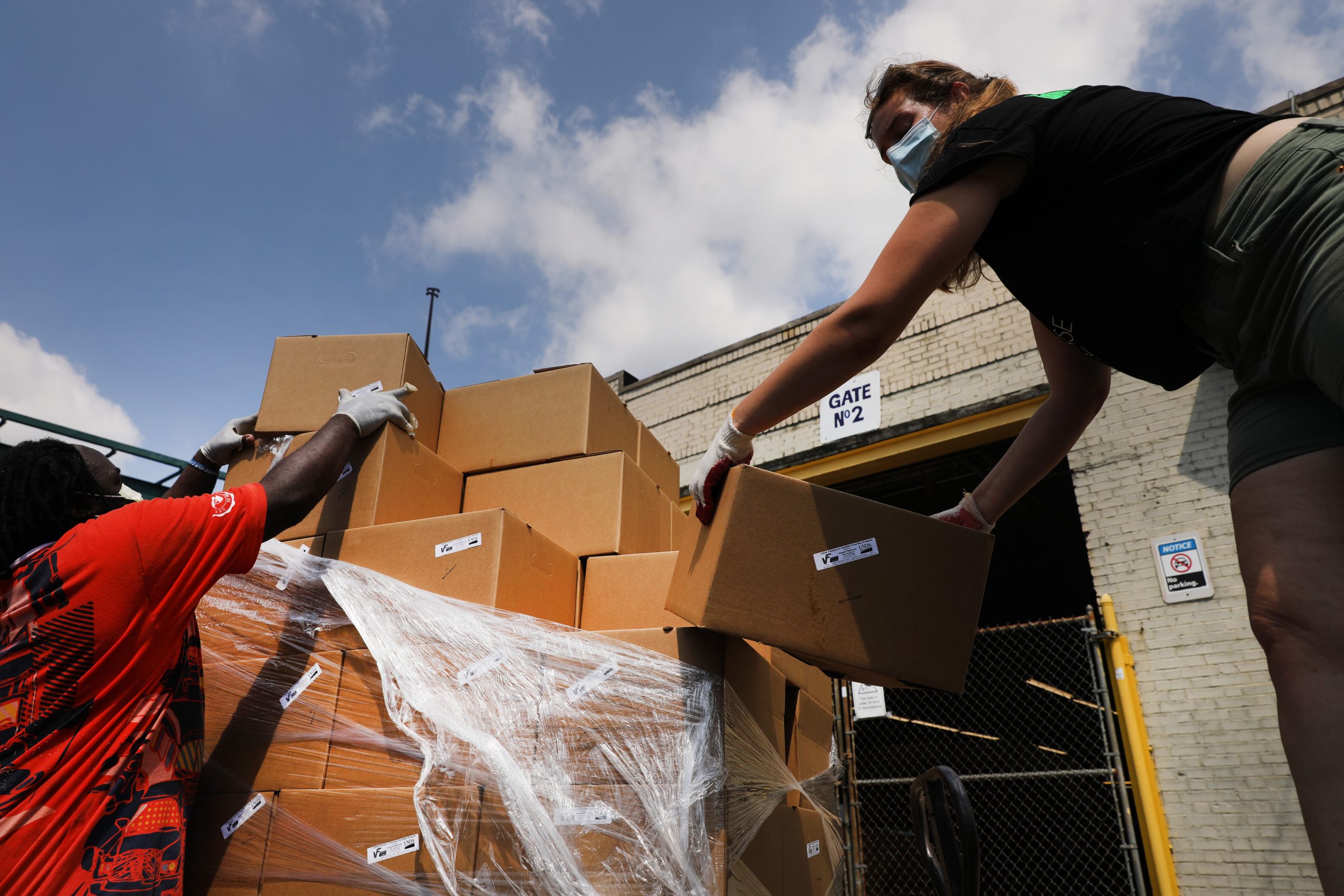 NEW YORK, NEW YORK - JULY 22: Members of Universe City, a decentralized food hub in the Brownsville neighborhood that is working to build food sovereignty while also promoting community healing practices, pack boxes of fresh produce delivered from City Harvest which will be distributed to area food banks, community leaders and other places to serve New Yorkers in need of food on July 22, 2020 in the Brooklyn borough of New York City. Universe City also operates an outside refrigerator that lets members of the community pick up fresh food for free. While many New York neighborhoods have long depended on charities, food banks and nonprofits to meet their nutritional needs, the COVID-19 pandemic has only multiplied the number of residents experiencing food insecurity. Across the city groups that serve those in need are seeing a huge increase in clients. According to the mayor’s office, an estimated 2 million people are currently food insecure in New York City, which is up from 1 million people before the pandemic. (Photo by Spencer Platt/Getty Images)