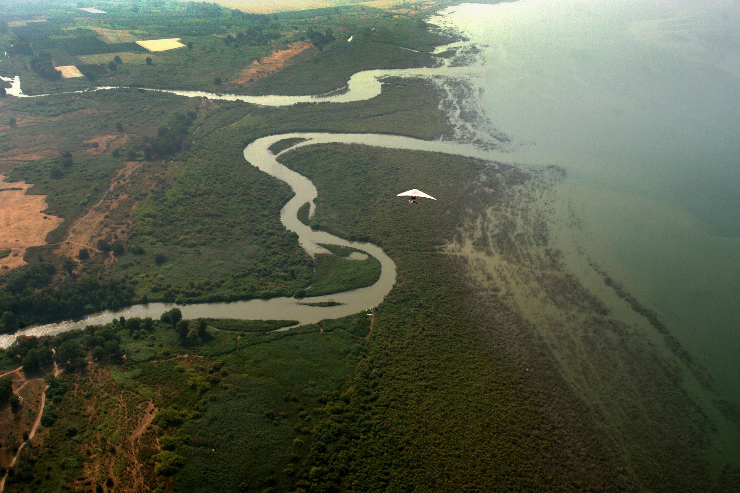 SEA OF GALILEE, ISRAEL - JUNE 1: A microlight aeroplane flies low towards the Golan Heights where the Jordan River empties into the Sea of Galilee, during an annual visit by members of the Israeli Ultralight Association on June 1, 2007 to the Golan Heights. Indirect peace negotiations between Israel and Syria are expected to start again on Thursday June 12, 2008 in Istanbul, Turkey, casting doubt on Israel's control of the strategic territory which it captured from Syria in the 1967 Six Day War. (Photo by Yuval Nadel/Getty Images)