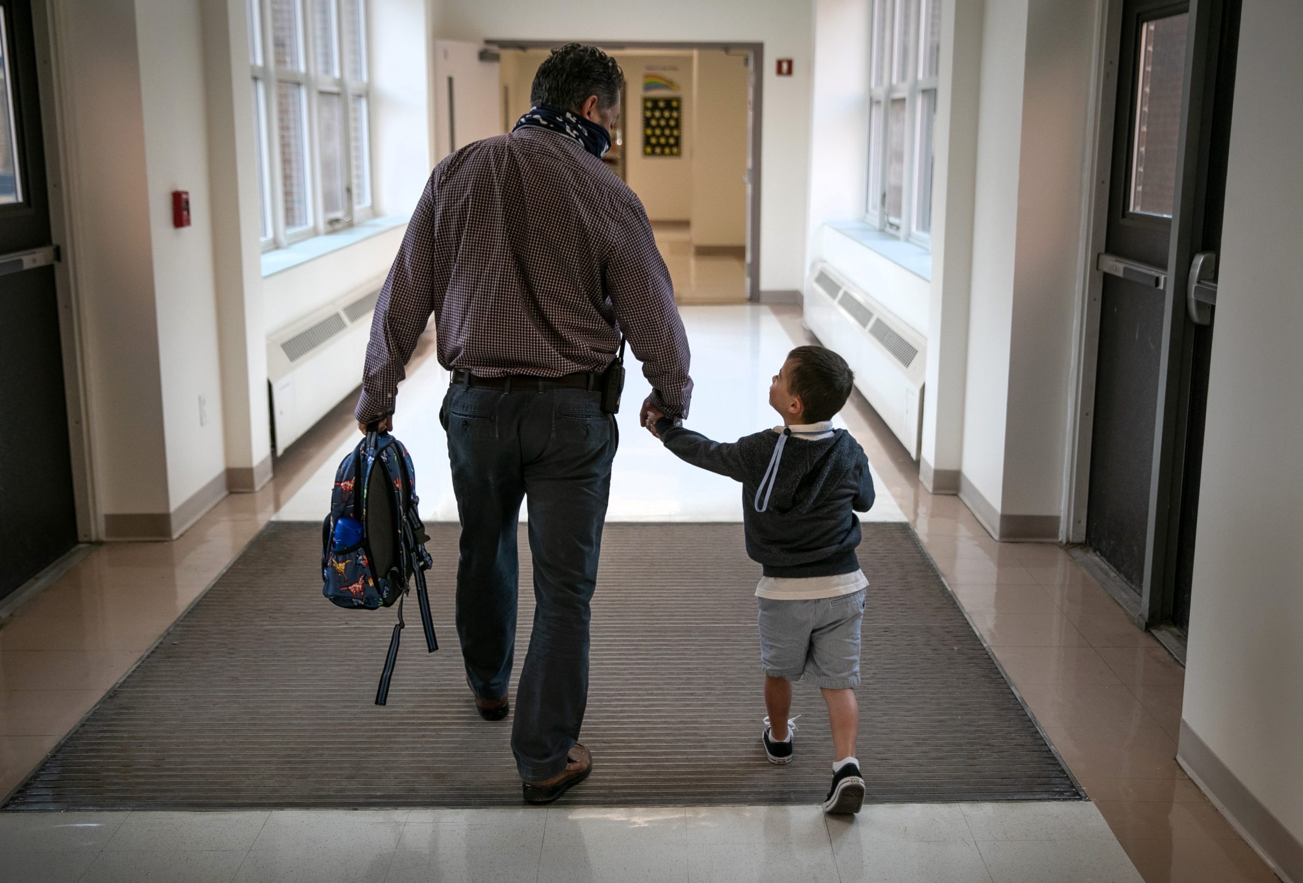 STAMFORD, CONNECTICUT - SEPTEMBER 16: Assistant principal Joe Claps escorts a child to class at Stark Elementary School on September 16, 2020 in Stamford, Connecticut. Most students at Stamford Public Schools are taking part in a hybrid education model, where they attend in-school classes every other day and distance learn the rest. About 20 percent of students in the school district, however, are enrolled in the distance learning option due to coronavirus concerns. (Photo by John Moore/Getty Images)