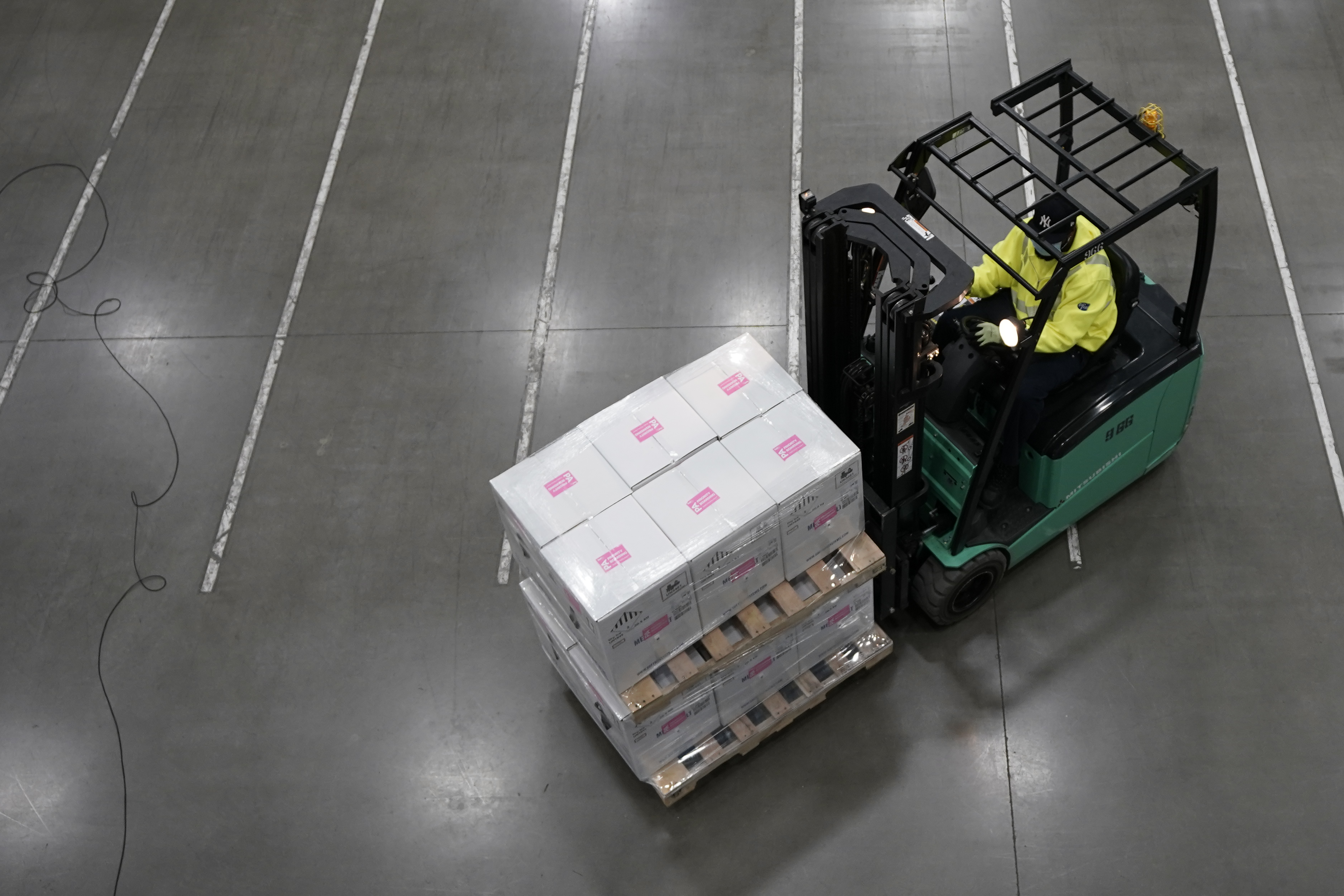 a man driving a forklift with boxes on it