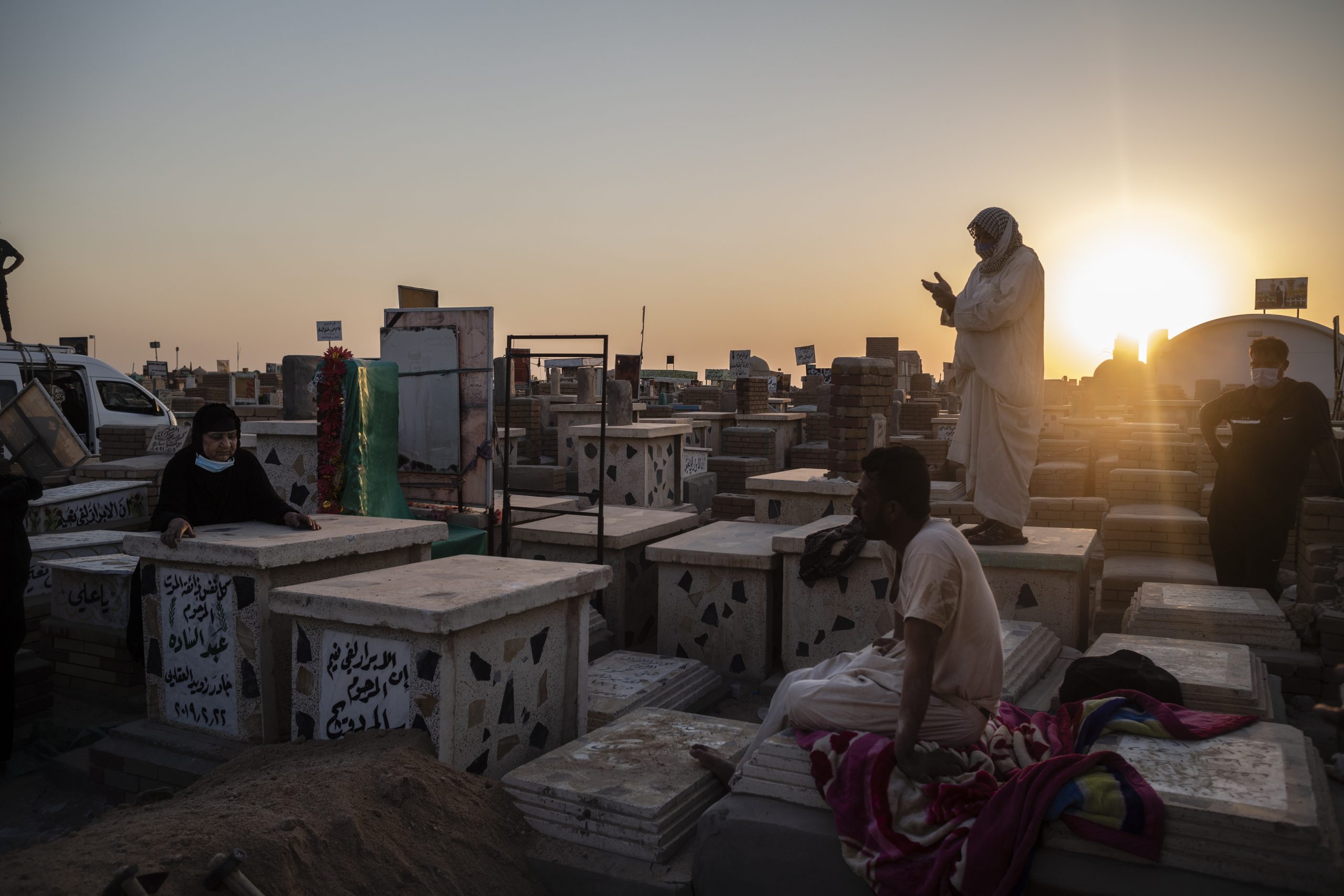 NAJAF, IRAQ - AUGUST 30: Relatives bury a family member who died from coronavirus at the Wadi Al-salam cemetery on August 30, 2020 in Najaf, Iraq. On September 4, Iraq recorded 5,036 coronavirus cases, its biggest daily increase since the start of the outbreak.  The surge has prompted warnings from Iraq's health minister and WHO that the country could be on the verge of a health crisis as pressure mounts on the already strained healthcare system. Since the first case was recorded in February, Iraq has recorded 252,075 total cases and 7,359 deaths. (Photo by Hawre Khalid/Getty Images)