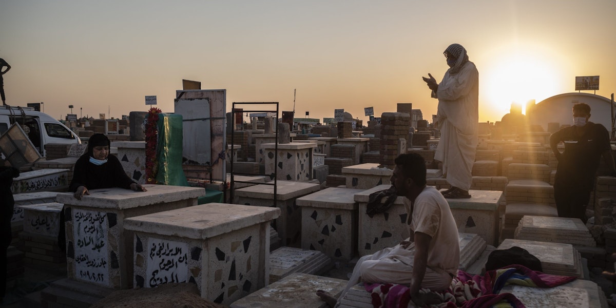 NAJAF, IRAQ - AUGUST 30: Relatives bury a family member who died from coronavirus at the Wadi Al-salam cemetery on August 30, 2020 in Najaf, Iraq. On September 4, Iraq recorded 5,036 coronavirus cases, its biggest daily increase since the start of the outbreak. The surge has prompted warnings from Iraq's health minister and WHO that the country could be on the verge of a health crisis as pressure mounts on the already strained healthcare system. Since the first case was recorded in February, Iraq has recorded 252,075 total cases and 7,359 deaths. (Photo by Hawre Khalid/Getty Images)