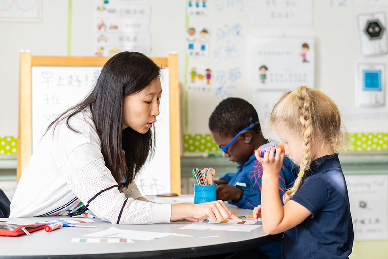 a woman sitting at a table with two children
