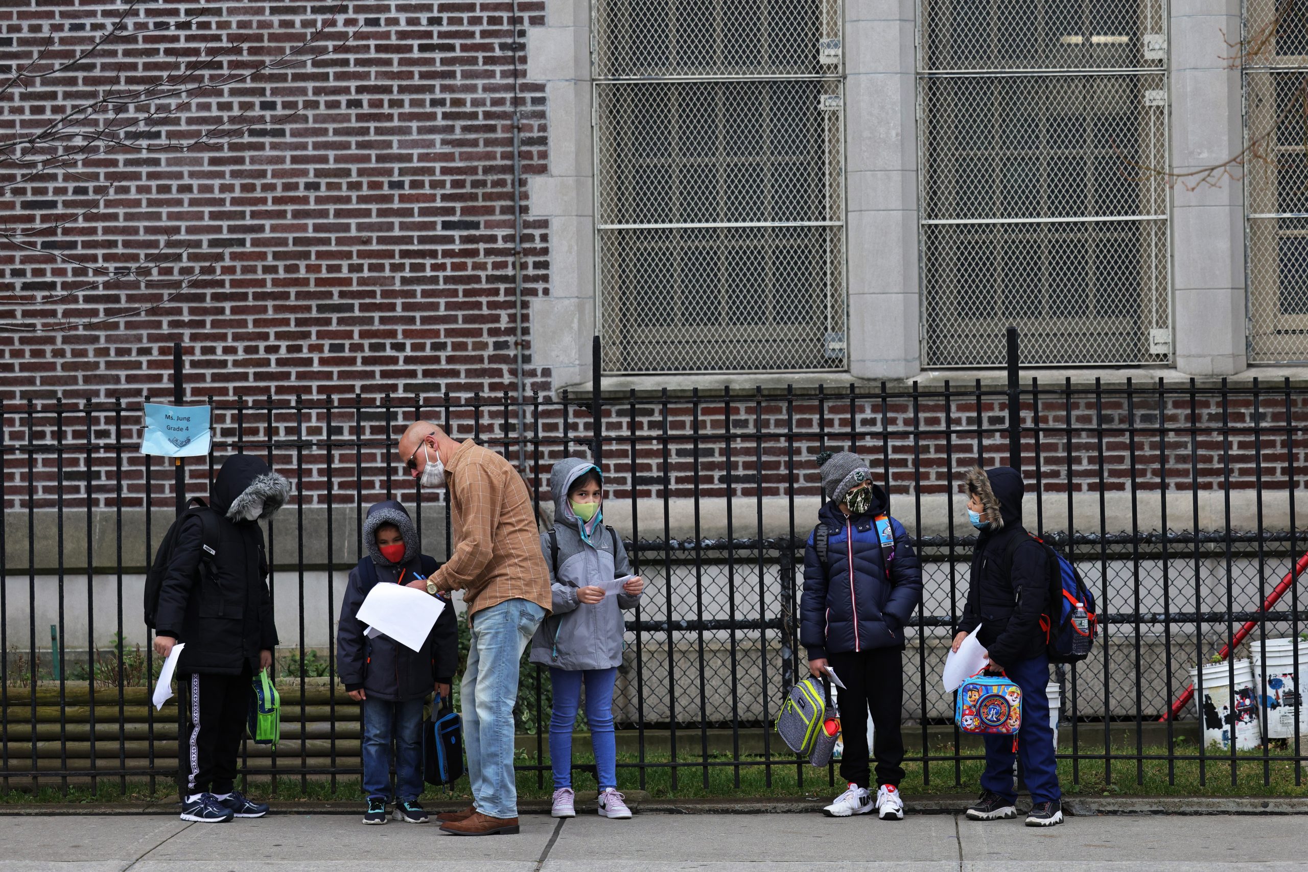NEW YORK, NEW YORK - DECEMBER 07: Children returning to school line up before entering P.S. 179 Kensington on December 07, 2020 in New York City. The New York City public school system opened for in-person learning 10 days after being shut down by Mayor Bill De Blasio due to a rising number of coronavirus (COVID-19) positive cases in the city. (Photo by Michael M. Santiago/Getty Images)