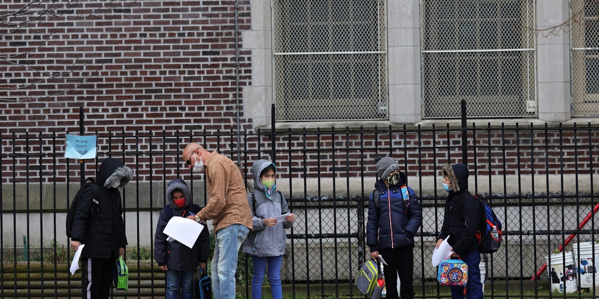 NEW YORK, NEW YORK - DECEMBER 07: Children returning to school line up before entering P.S. 179 Kensington on December 07, 2020 in New York City. The New York City public school system opened for in-person learning 10 days after being shut down by Mayor Bill De Blasio due to a rising number of coronavirus (COVID-19) positive cases in the city. (Photo by Michael M. Santiago/Getty Images)