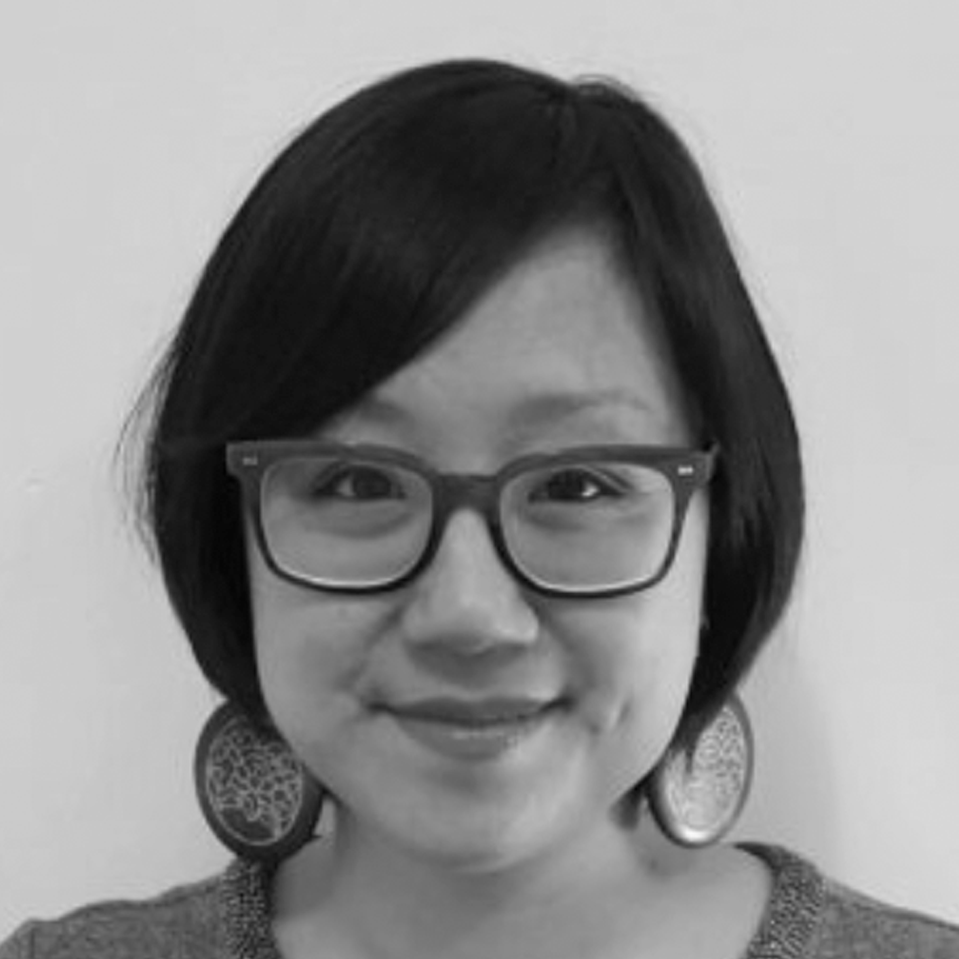 a woman wearing glasses and smiling for the camera