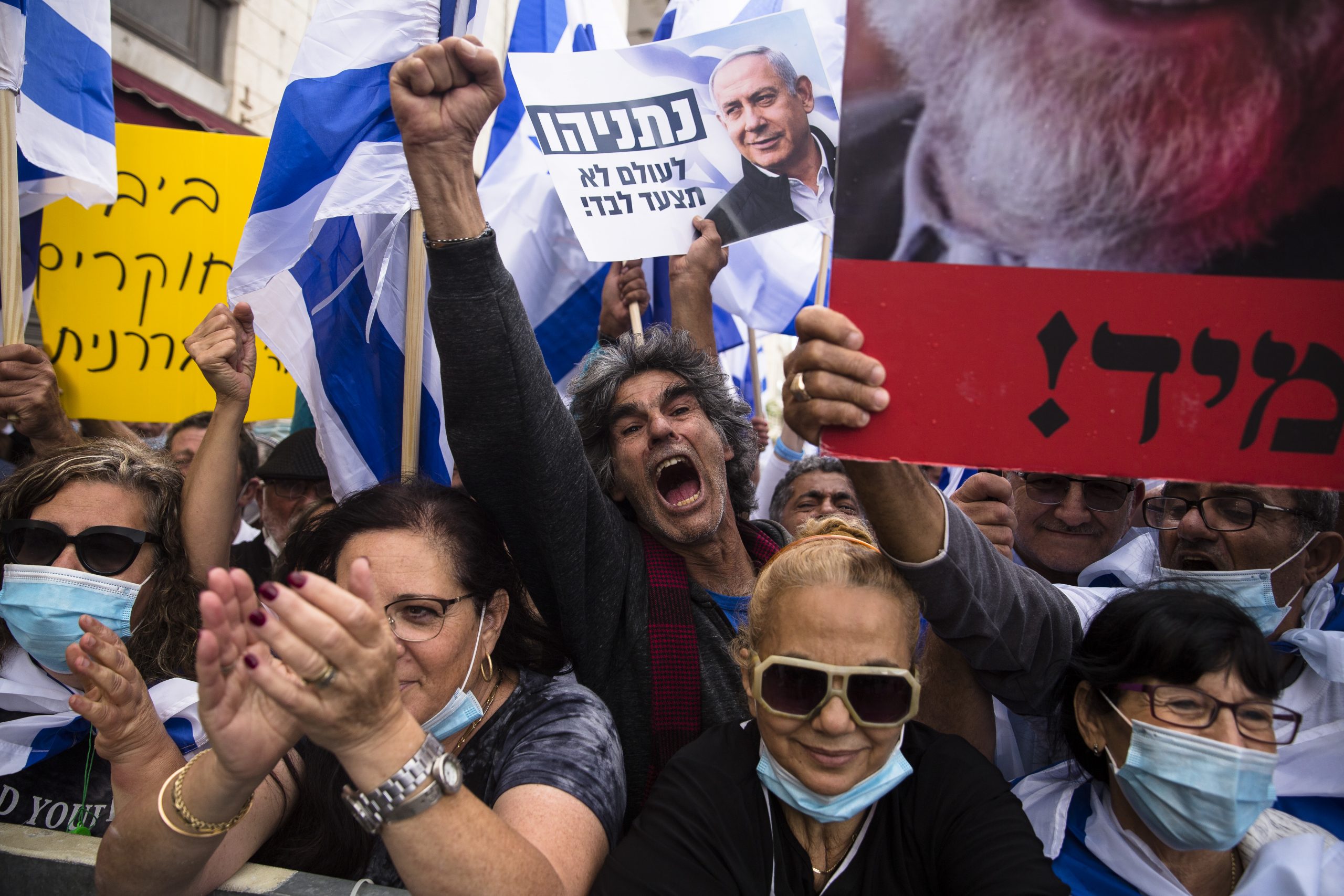 JERUSALEM, ISRAEL - MAY 24:  Israelis protest in support Israeli Prime Minister, Benjamin Netanyahu near the district court on May 24, 2020 in Jerusalem, Israel. The prime minister, who strongly denies the charges of bribery, fraud and breach of trust, was recently sworn in to office at the head of a national unity government formed with his opponent Benny Gantz.  (Photo by Amir Levy/Getty Images)