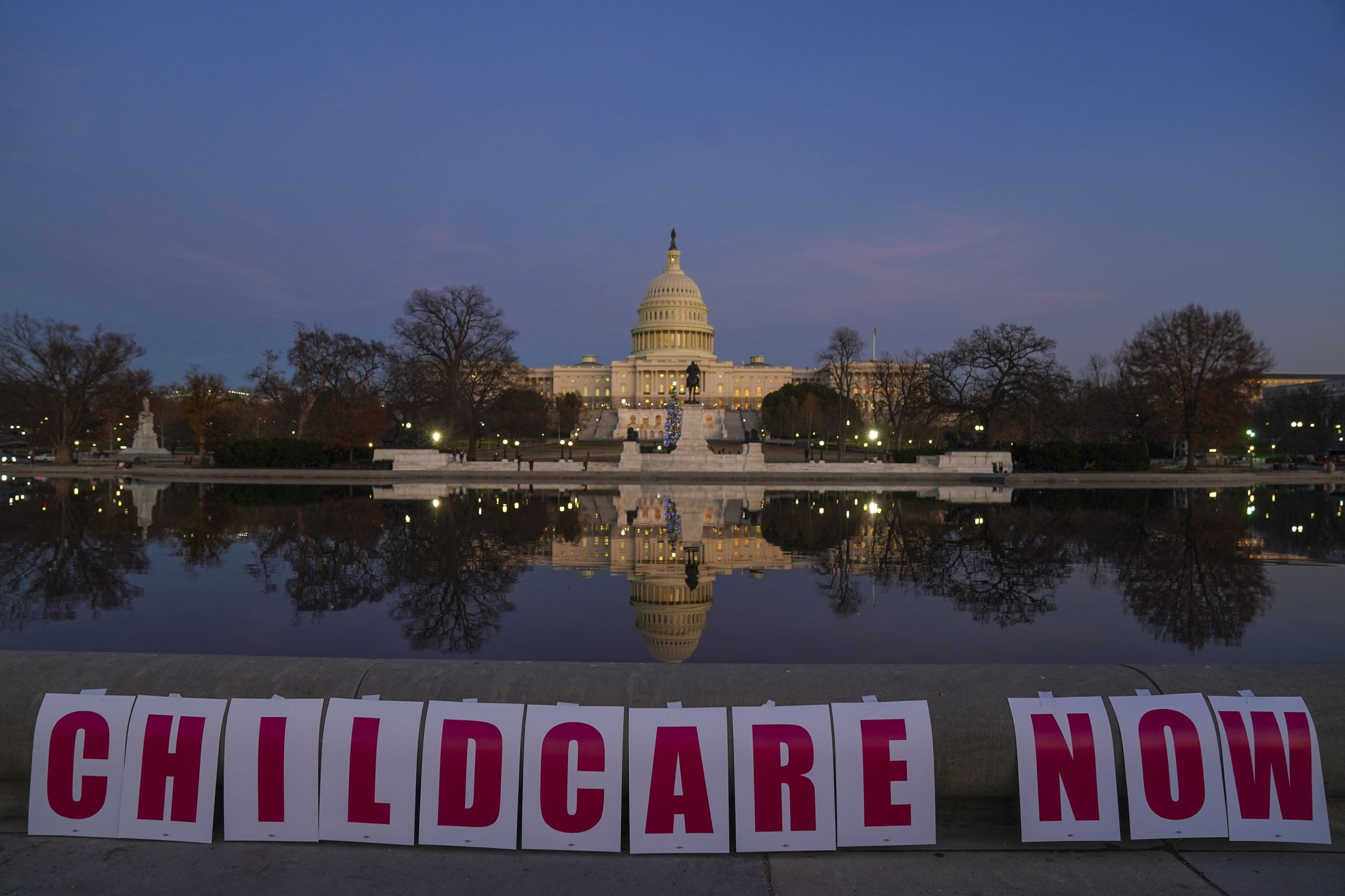 WASHINGTON, DC - DECEMBER 14: Childcare Now is spelled out on signs during Child Care Providers and Parents Rally to Pass Build Back Better at the U.S. Capitol on December 14, 2021 in Washington, DC. 50 years after President Nixon vetoed child care legislation, parents and providers rally to ensure child care is passed through Build Back Better. (Photo by Leigh Vogel/Getty Images for Child Care For Every Family Network)