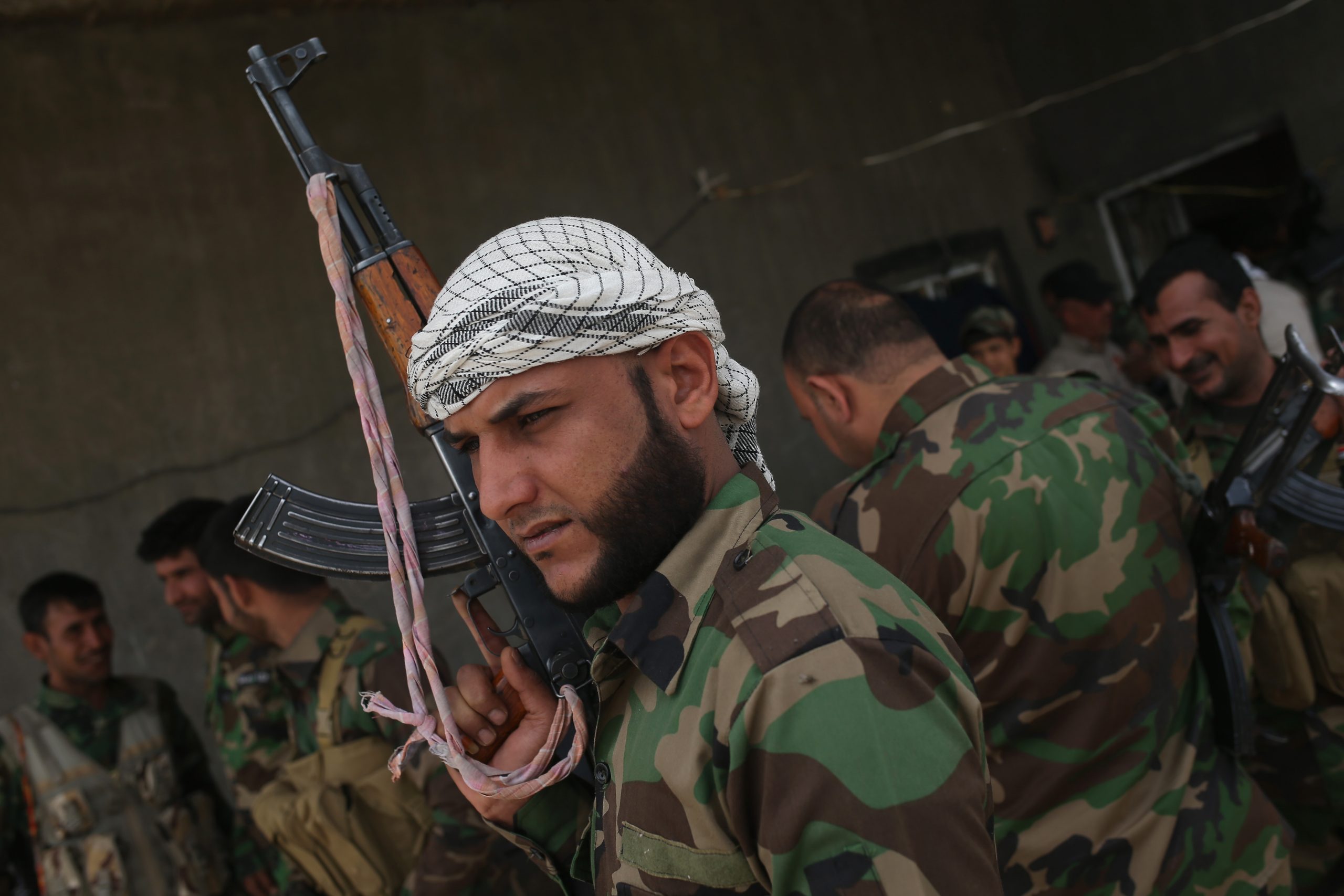 EBRAHIM BEN ALI, IRAQ - APRIL 11:  Volunteers from the Shia Badr Brigade gather after an exchange of fire with ISIS fighters on the frontline on April 11, 2015 in Ebrahim Ben Ali, in Anbar Province, Iraq. Shia militia and Iraqi government troops are preparing for an assault on ISIS forces in Anbar, much of which was captured by ISIS forces last year. Anbar Province was the site of the some of the fiercest fighting between U.S. and insurgent forces before American troops withdrew in 2010.  (Photo by John Moore/Getty Images)