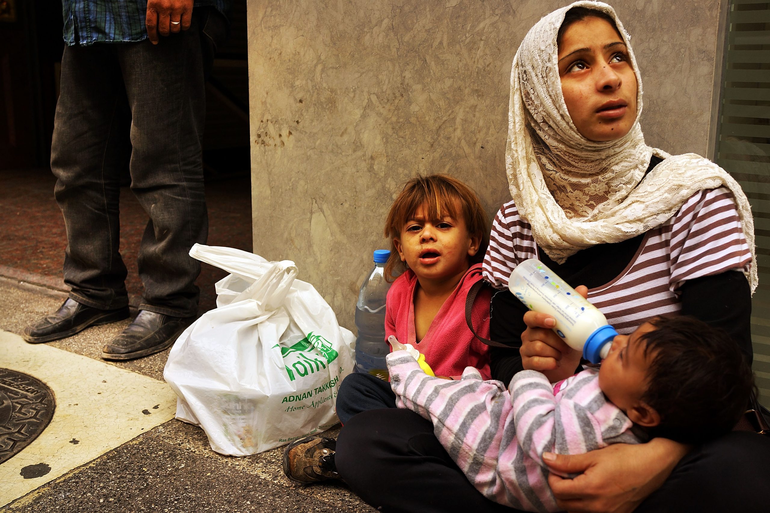 BEIRUT, LEBANON - NOVEMBER 16: Fatma, a Syrian woman from the city of Idlib, begs with her two children in a wealthy district of Beirut on November 16, 2013 in Beirut, Lebanon. As the war in neighboring Syria drags on for a third year, Lebanon, a country of only 4 million people, is now home to the largest number of Syrian refugees who have fled the conflict. The situation is beginning to put huge social and political strains on Lebanon as there is currently no end in sight to the war in Syria. According to the United Nations, almost two million Syrian refugees have been forced to flee their homes due to the ongoing war. Of those, around half are believed to be children. While there is no official data on the number of children and adults working on the streets Lebanon, it is estimated that it could be anywhere from 50,000 to 70,000. In wealthy districts of Beirut children and adults are viewed on nearly every block begging, looking through trash or offering pedestrians a shoe shine.  (Photo by Spencer Platt/Getty Images)