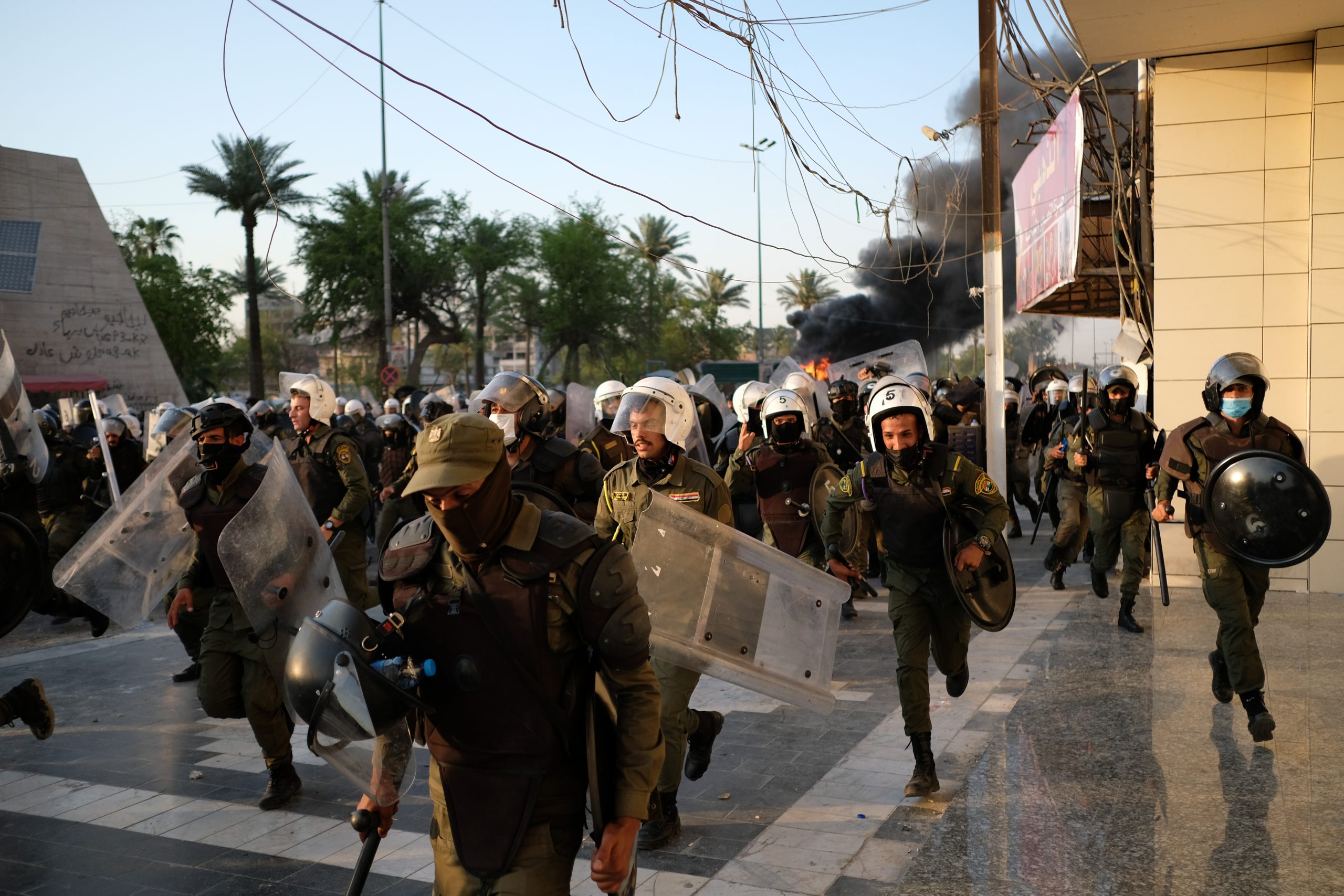 BAGHDAD, IRAQ - MAY 25: Riot police forces running away from protesters after clashes during anti-government protest on May 25, 2021 in Baghdad, Iraq. Protesters from across the country gathered in Baghdad demanding accountability after a recent rise in targeted assassinations. The protests used the slogan 'Who killed me' to highlight the recent killings of activists, journalists and human rights advocates. (Photo by Taha Hussein Ali/Getty Images)