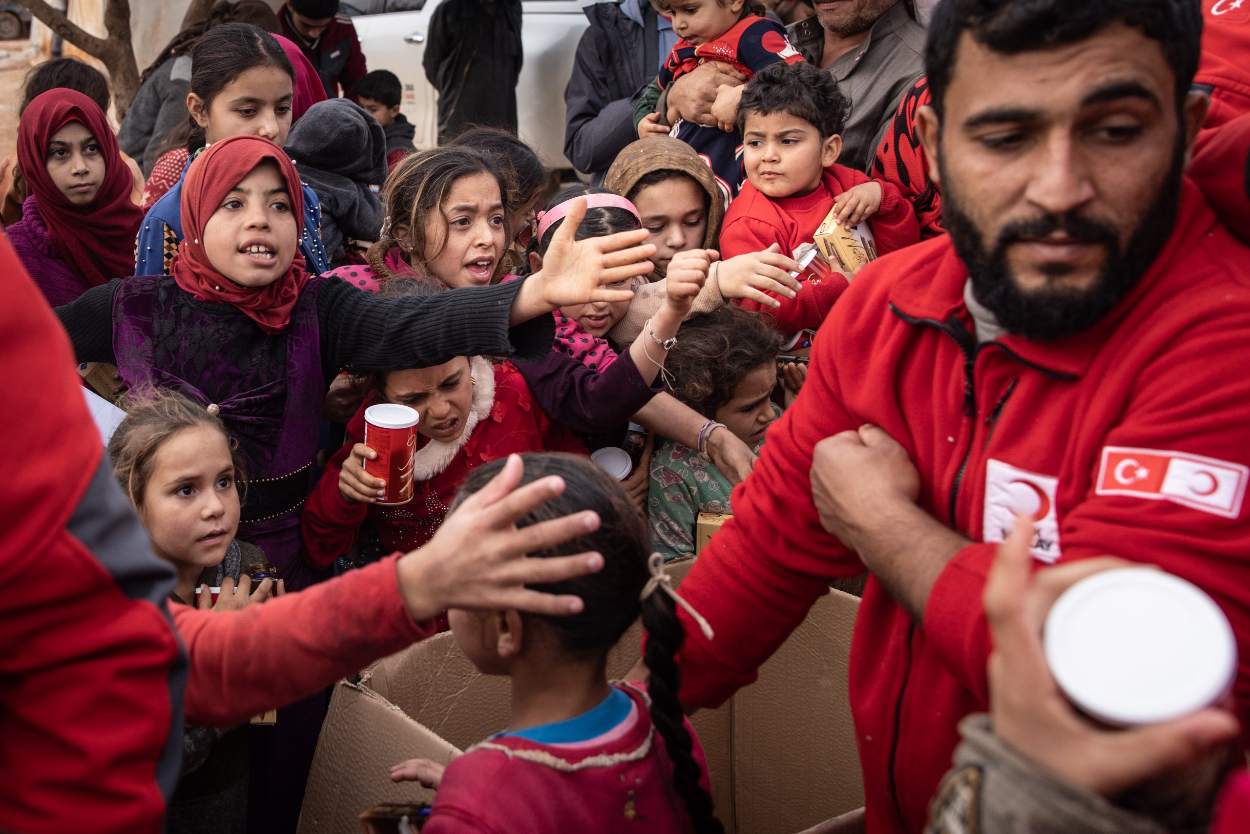 SARMADA, SYRIA - NOVEMBER 26: Displaced Syrian children wait to receive toys handed out by Turkish Red Crescent employees at a camp for displaced people supported by the Turkish Red Crescent on the outskirts of Idlib, on November 26, 2021 in Sarmada district, Idlib Province, Syria. The province's population has swelled over the course of Syria's 10-year civil war, as the rebel-held northwest became a refuge for Syrians with nowhere else to go. People here live in a patchwork of tents, brick homes and other improvised structures, some in camps supported by the Turkish Red Crescent, which provides food, blankets and toys. Amid the pandemic and looming threat of violence, humanitarian organizations and local authorities have struggled to meet these communities' overwhelming needs. (Photo by Chris McGrath/Getty Images)
